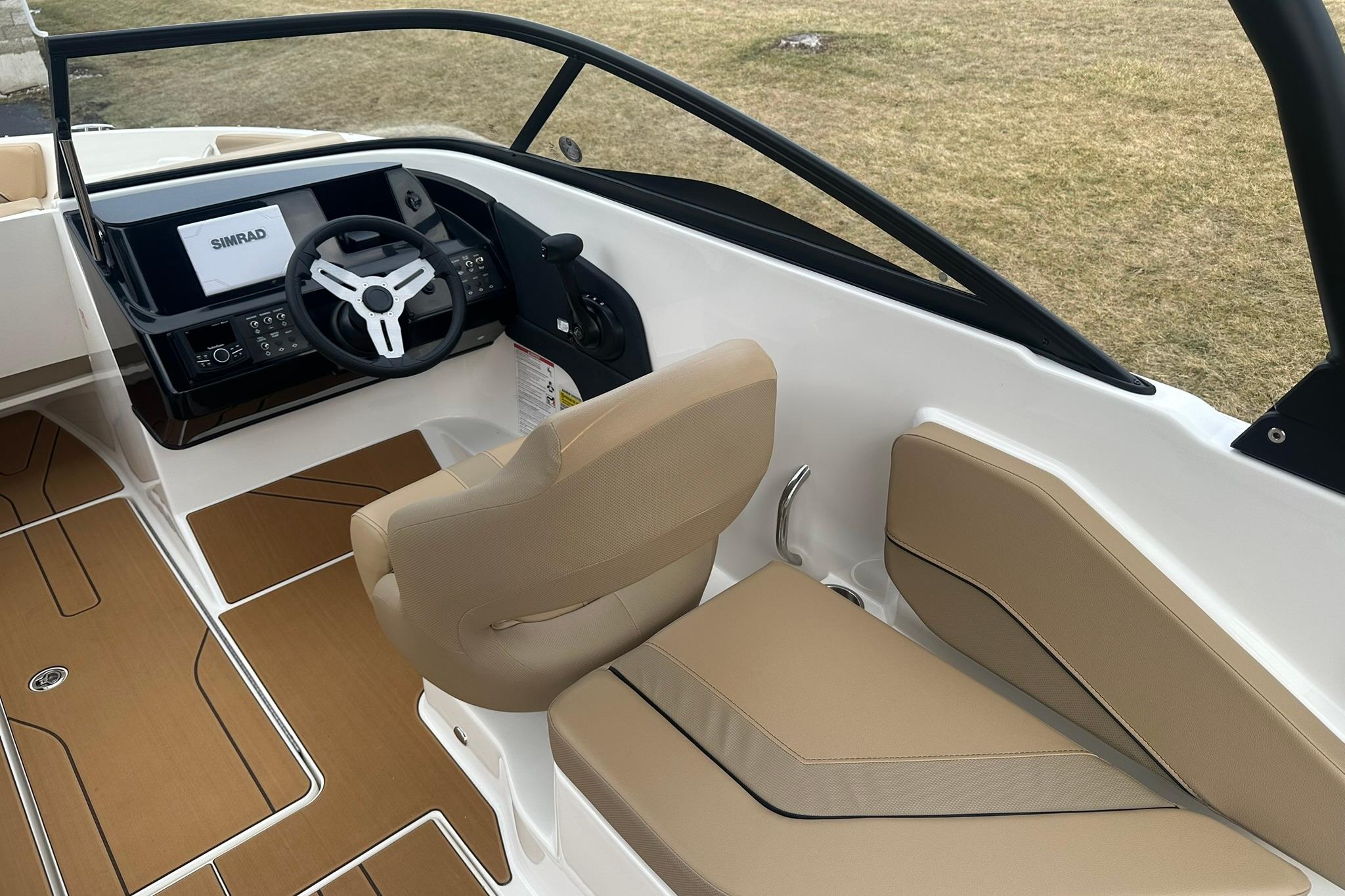 2026 Bayliner V20 boat interior with modern dashboard and beige seating.