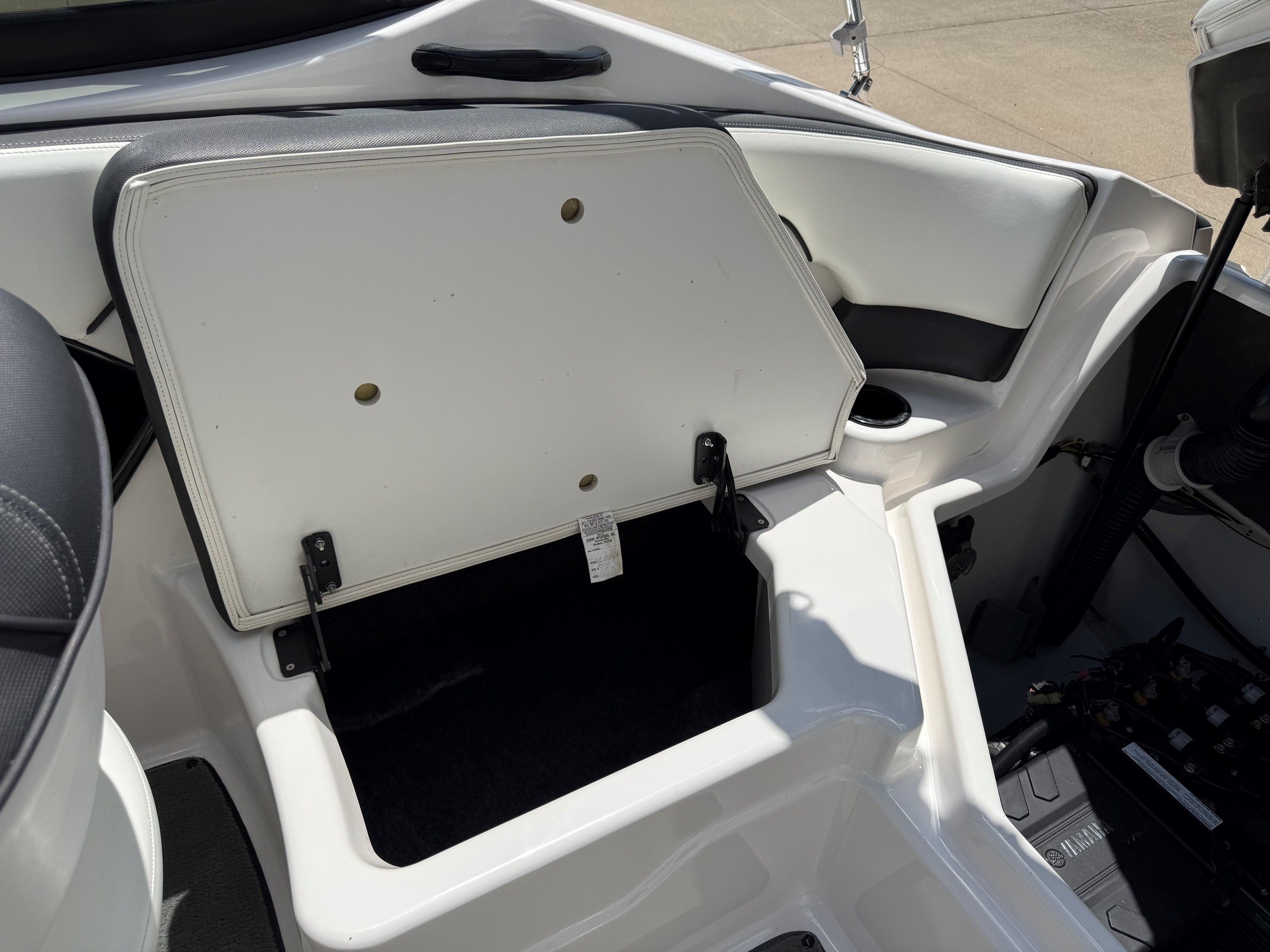 An open storage compartment on a Yamaha SX210 boat.