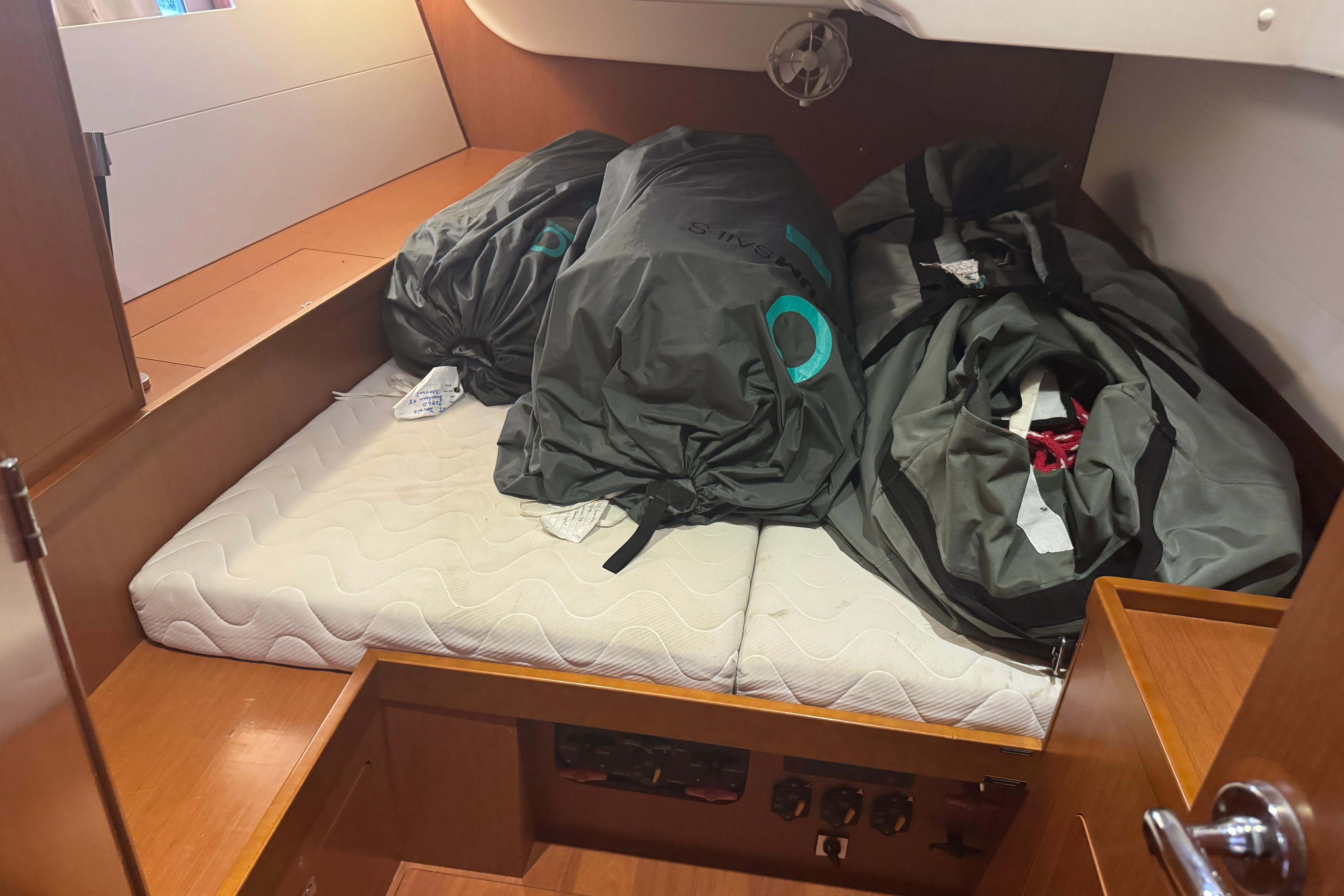 Cabin interior of 2015 Beneteau Oceanis 48 with storage bags on mattress.