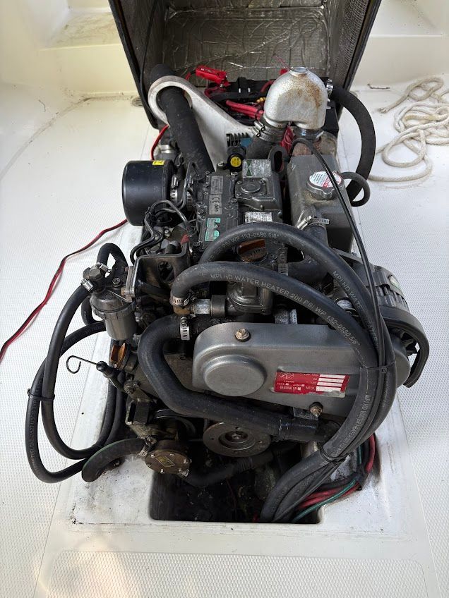 The engine compartment of a 2007 Ranger Tugs R-21 EC shows a compact engine with various hoses and wires.