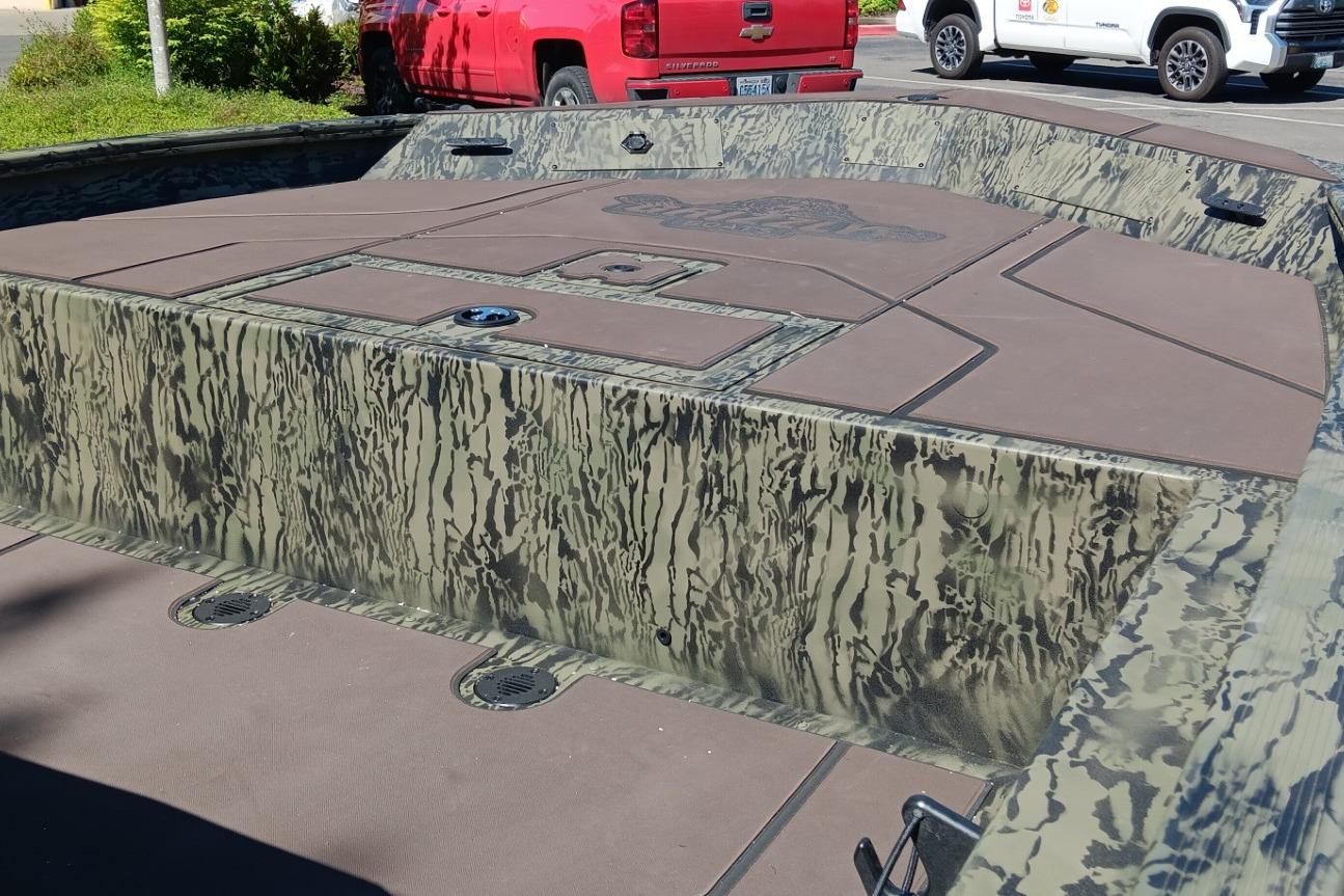 2026 Tracker Grizzly 1860 CC boat with camouflage design, parked outdoors.