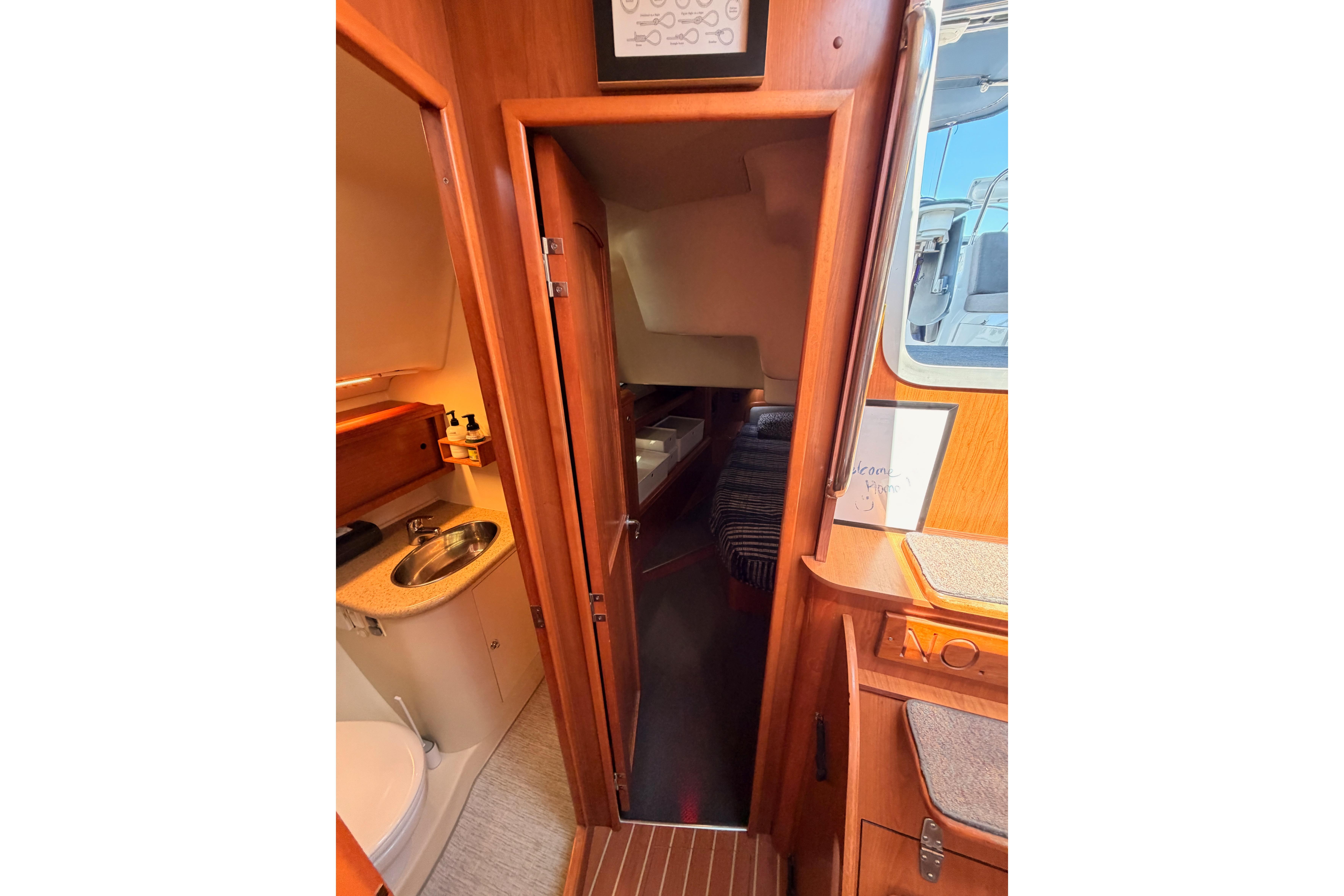 Interior view of 2008 Hunter 45 Deck Salon, featuring bathroom and cabin entrance.