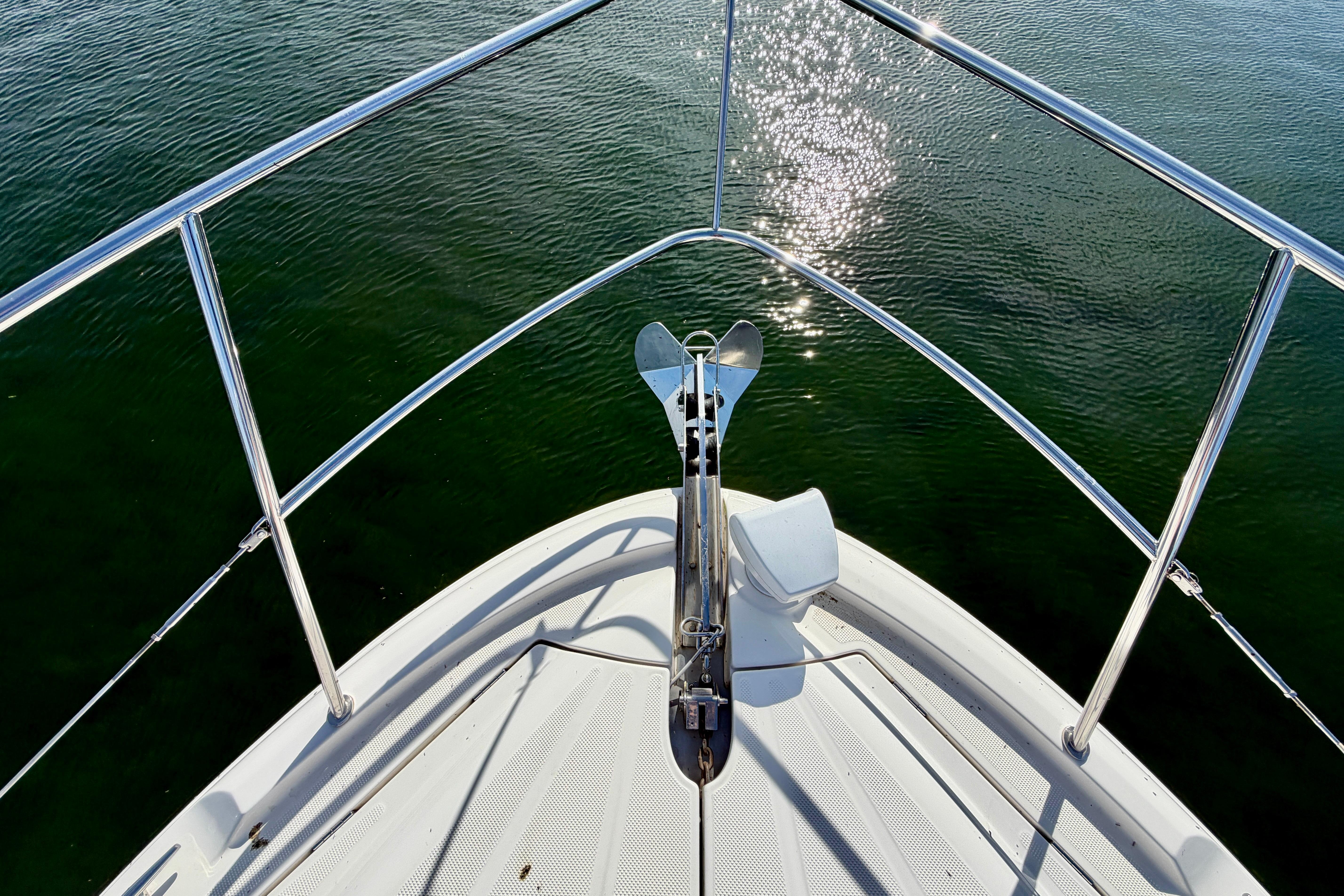 Bow of a 2011 Meridian 441 Sedan yacht with gleaming water reflections.
