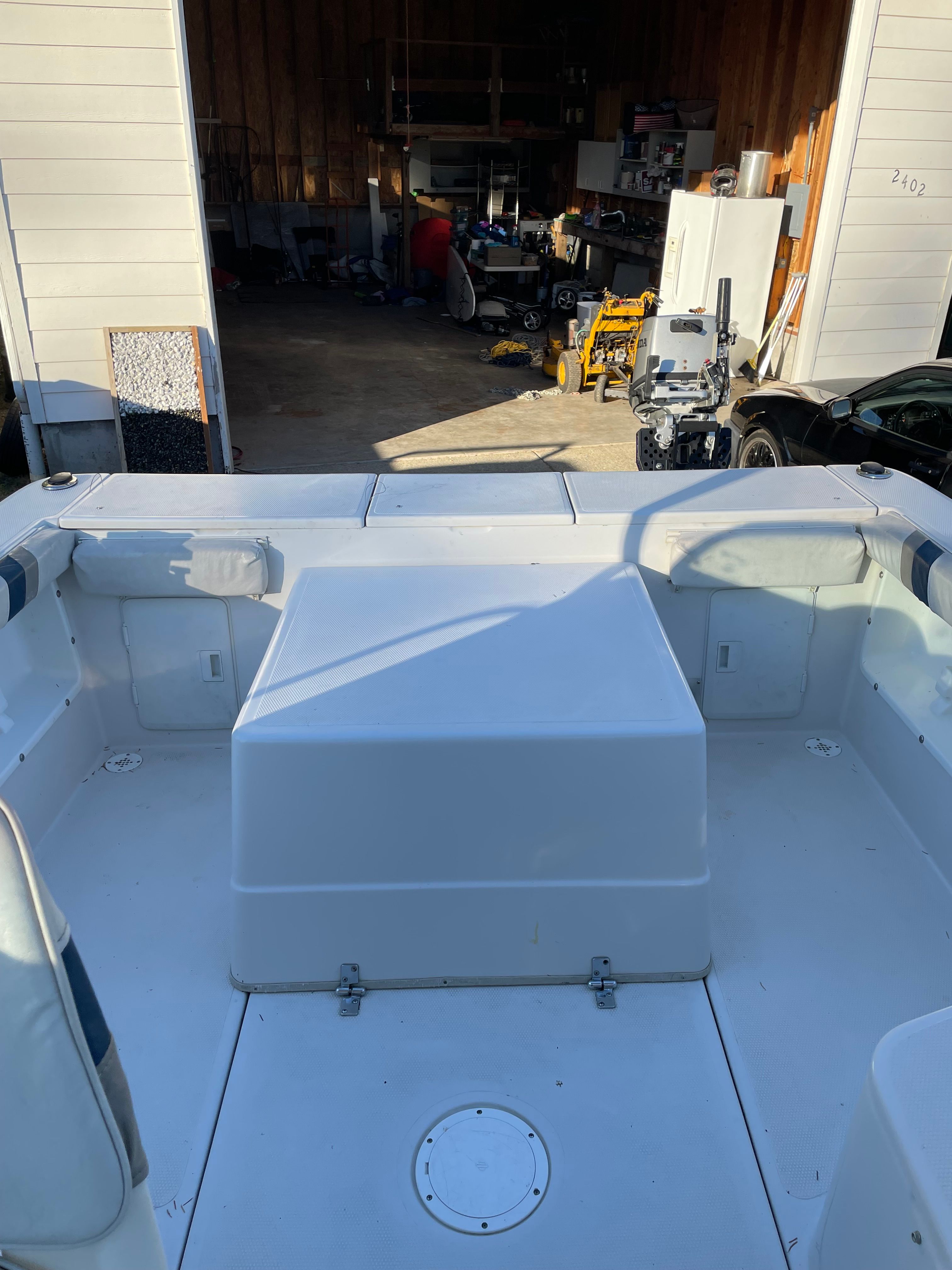 The image shows the open cockpit of a 2001 Bluewater 2100 sport fisher in a garage.