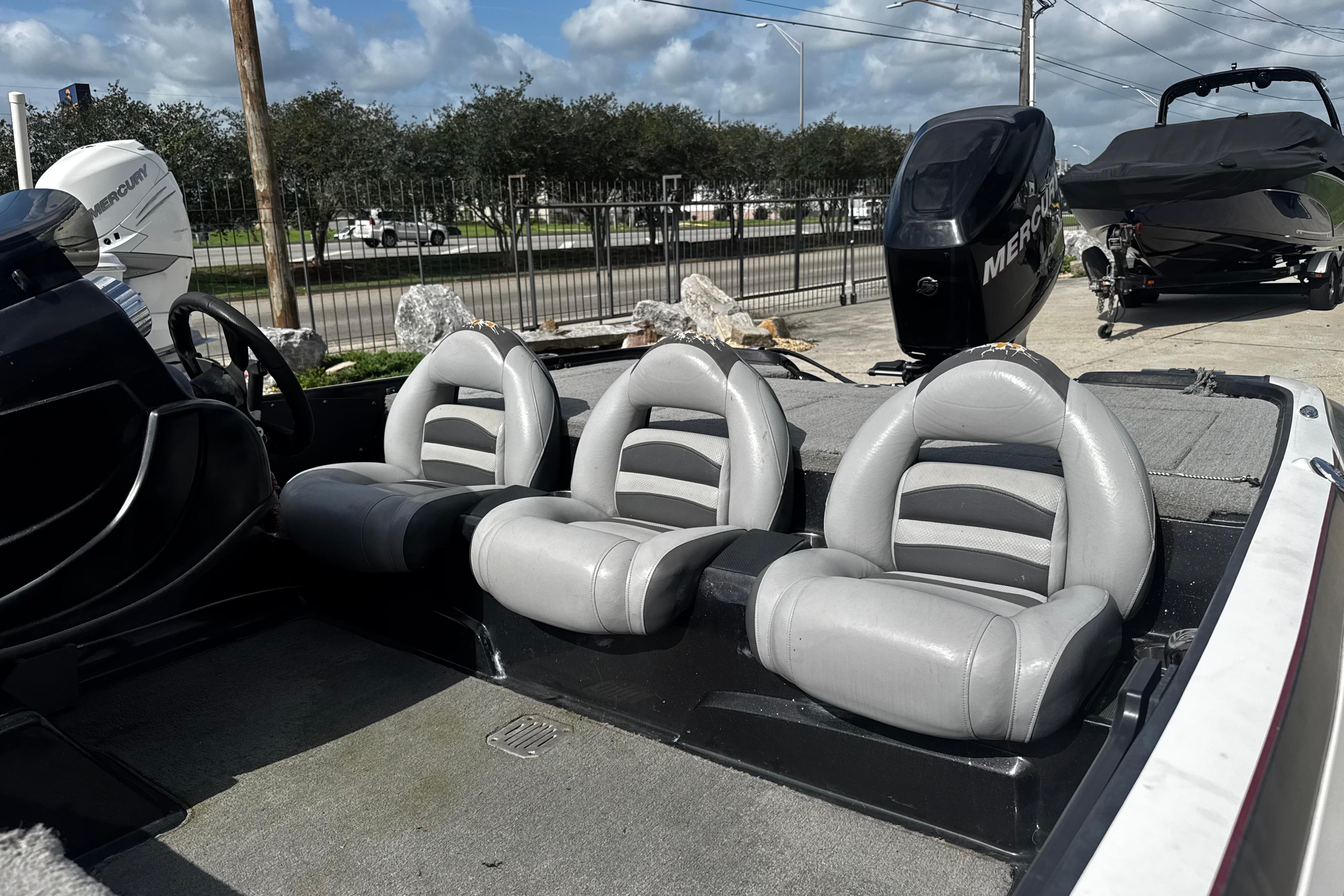 2012 Nitro Z-7 boat interior with three gray seats and Mercury outboard motor.
