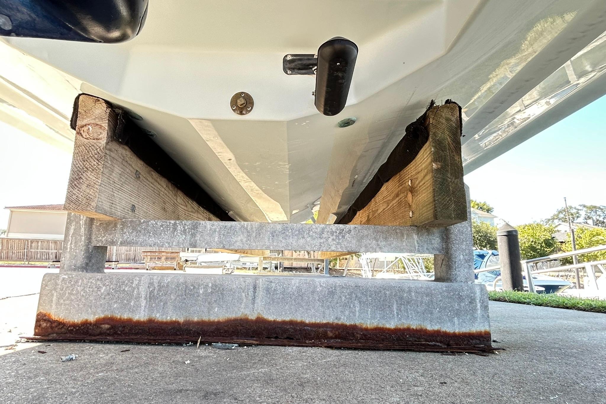 2019 Robalo 226 Cayman boat hull on wooden supports, dockside view.