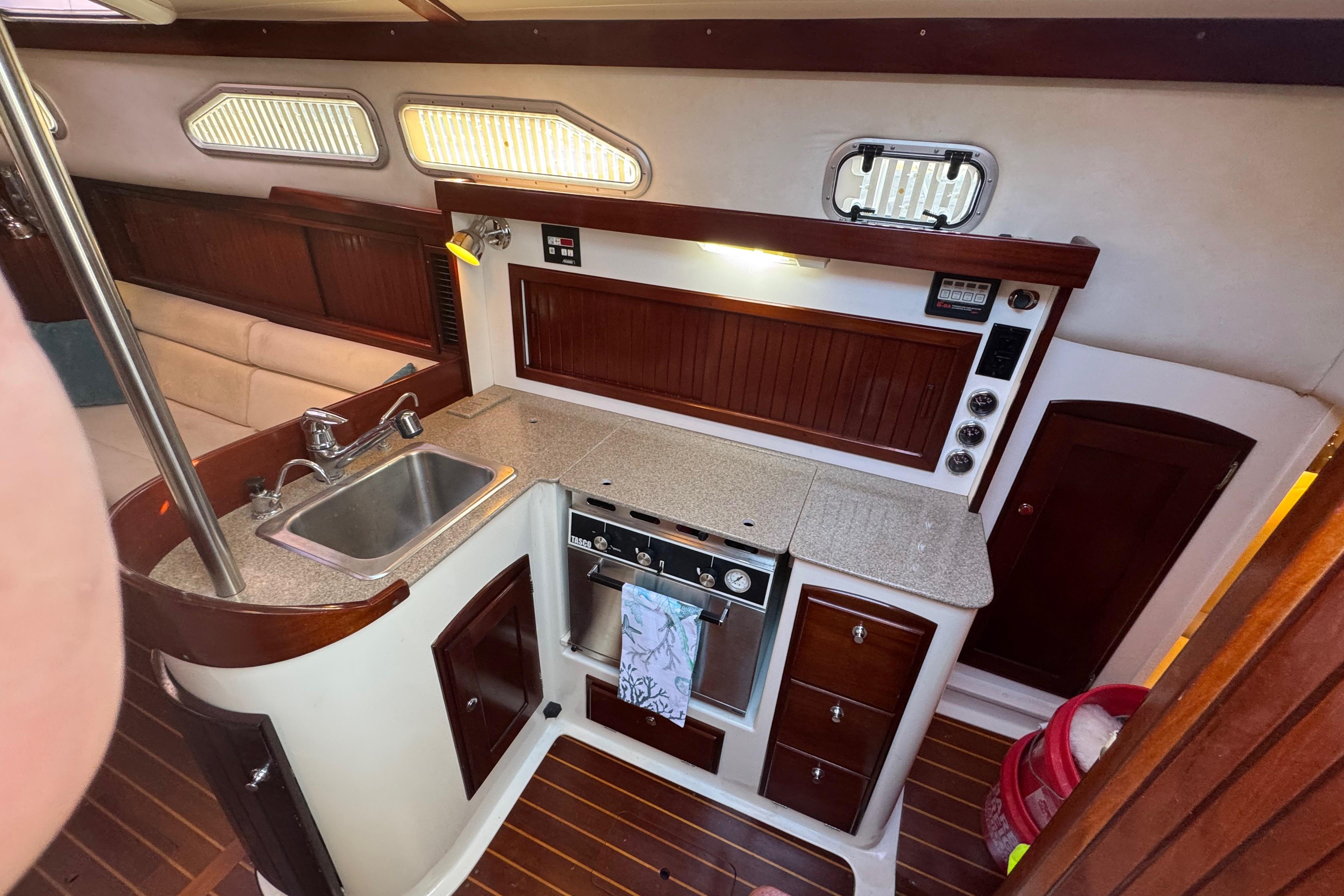 2006 Shannon Shoalsailer yacht interior with kitchen, sink, stove, and wooden cabinetry.