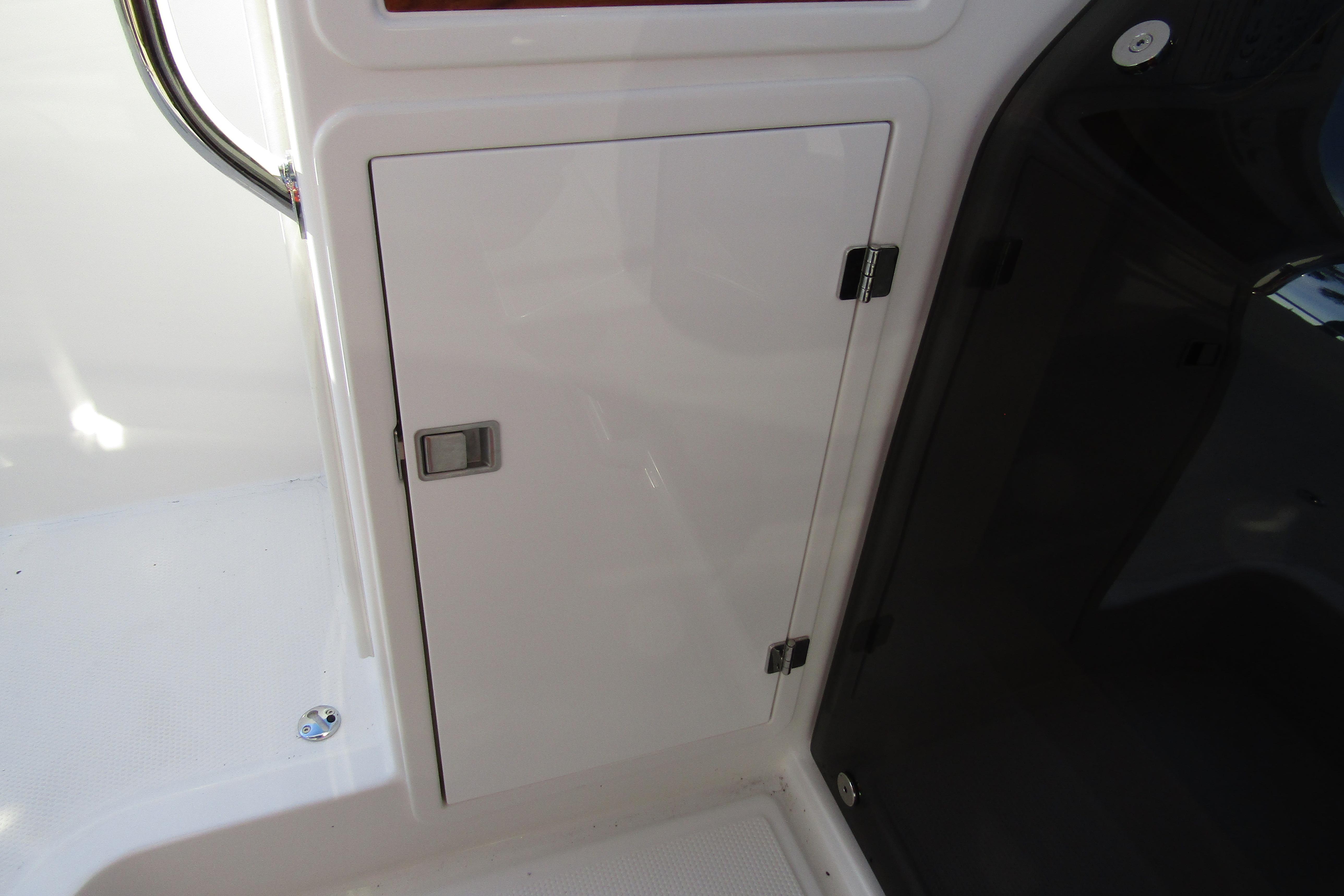 Storage compartment on 2025 Nimbus Tender 9 boat, featuring sleek white design and secure latch.