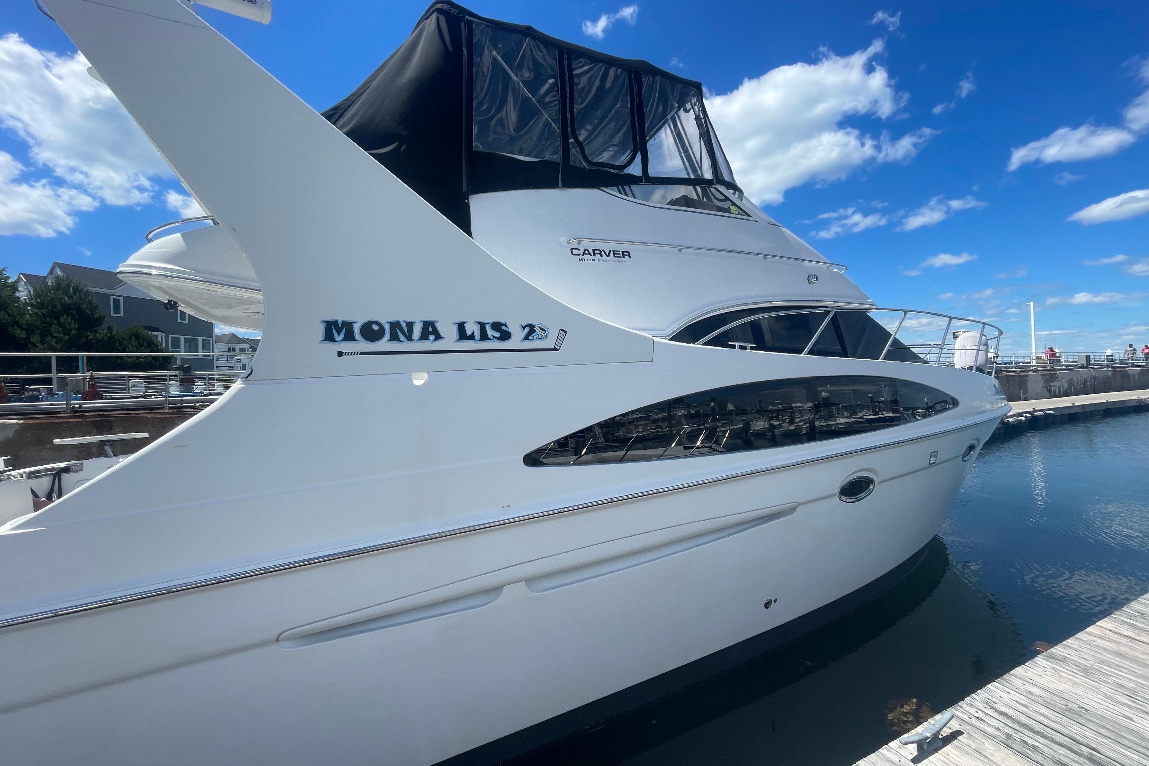 2002 Carver 410 Sport Sedan yacht docked under a clear blue sky.