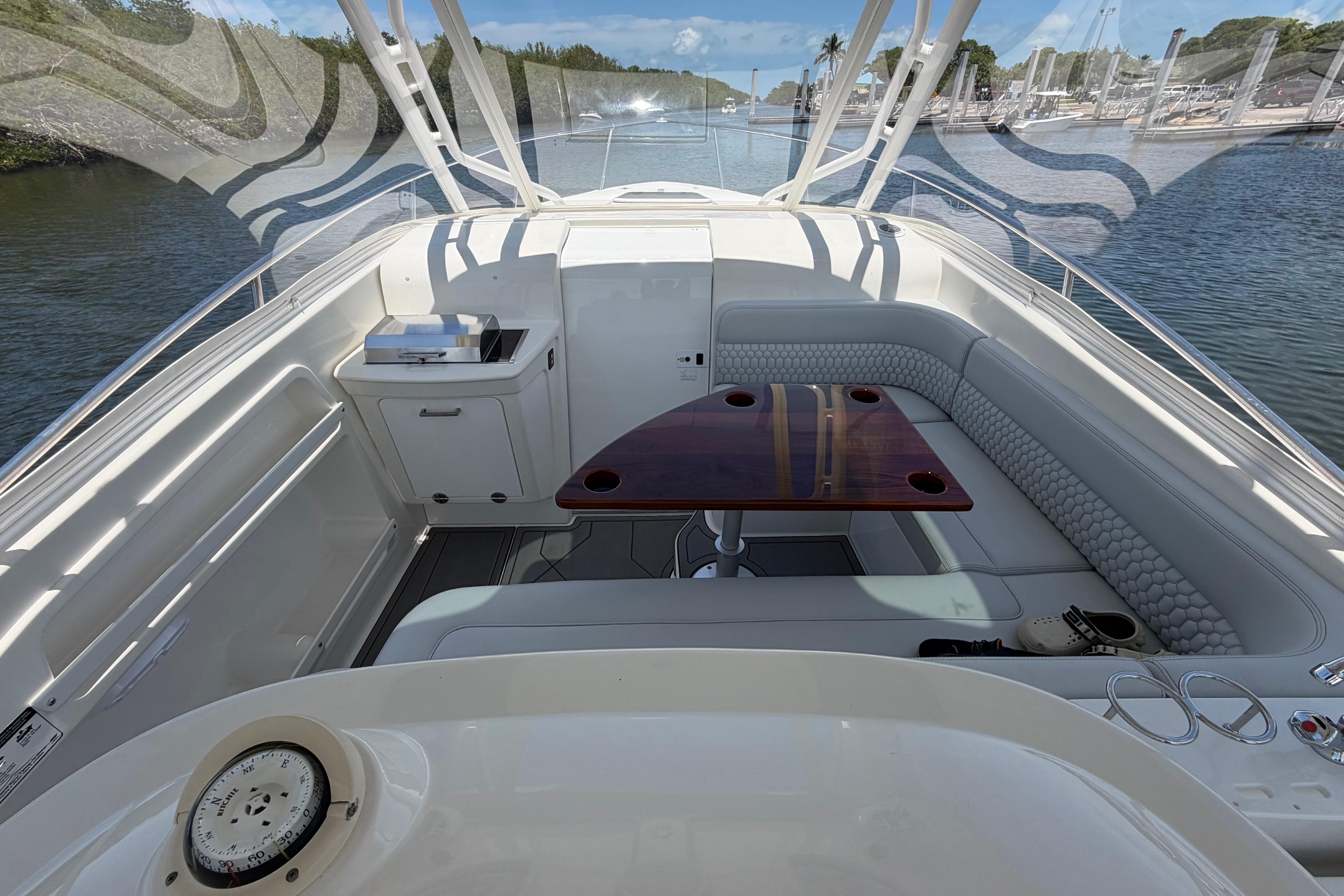 2009 Everglades 350LX boat interior with seating and table, docked in a marina.