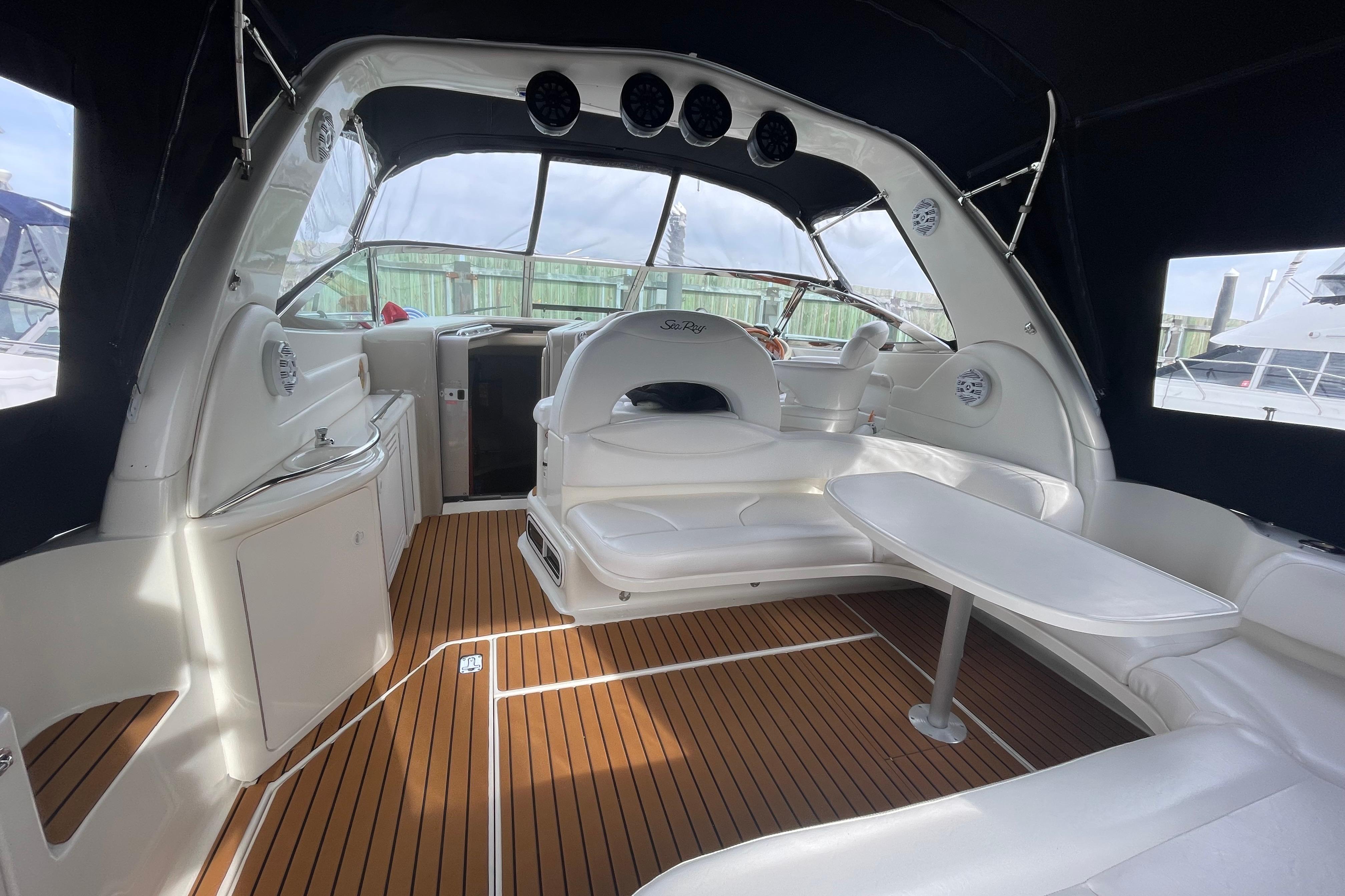 1999 Sea Ray 380 Sundancer interior with white seating, wooden flooring, and a sleek design.