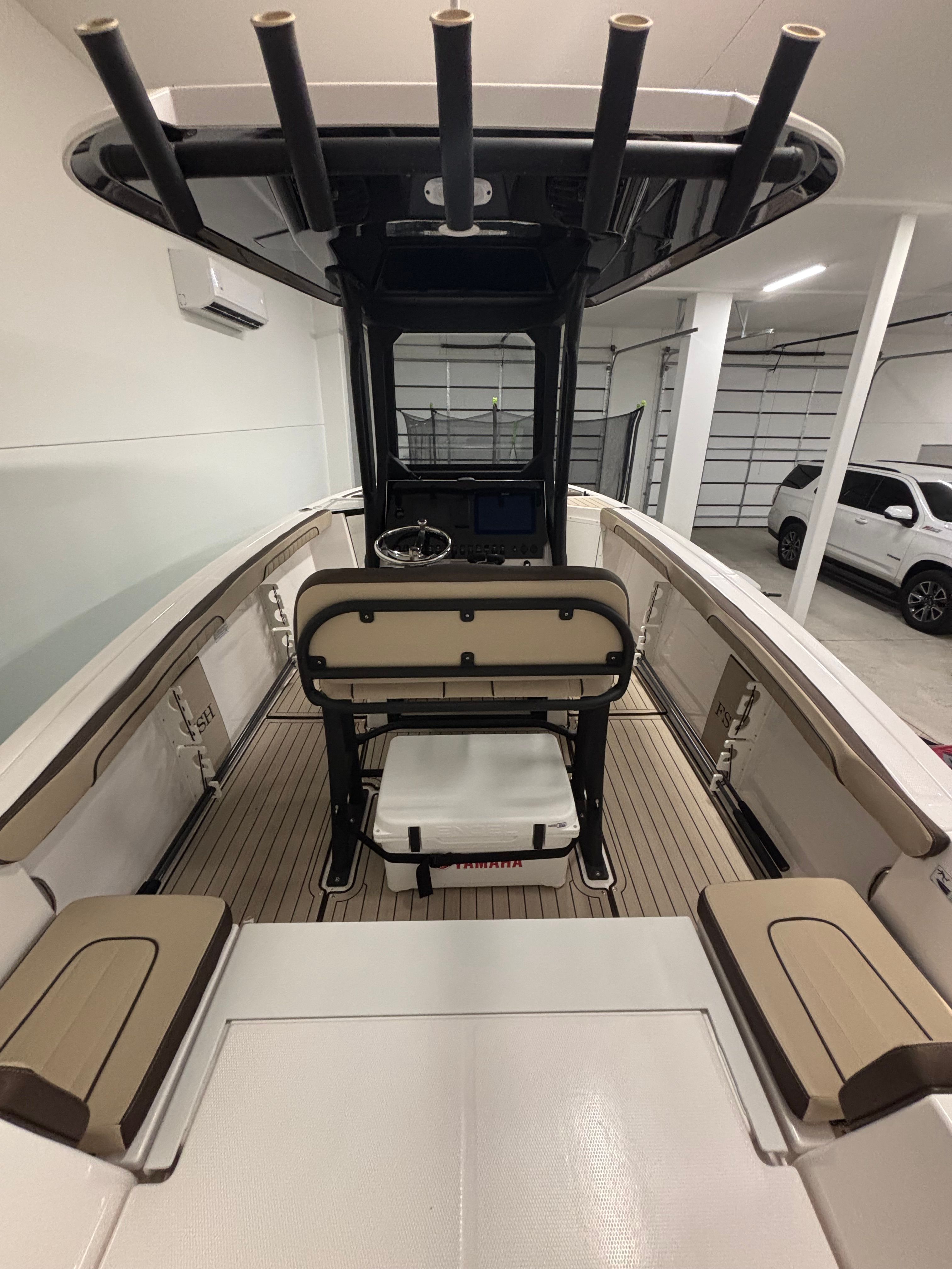 Interior view of a modern boat with seating benches and a helm station.