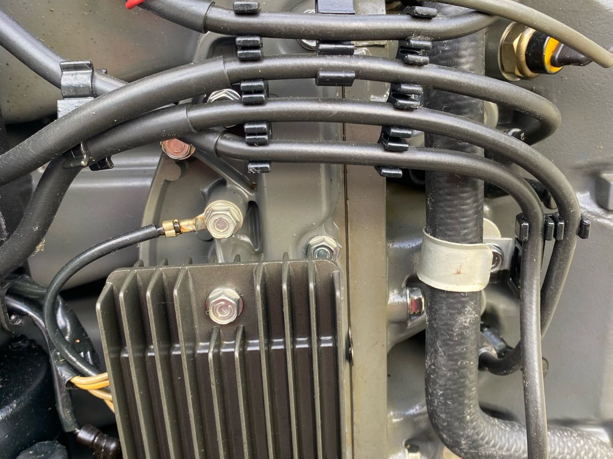 Close-up of an engine part with wires and connectors.