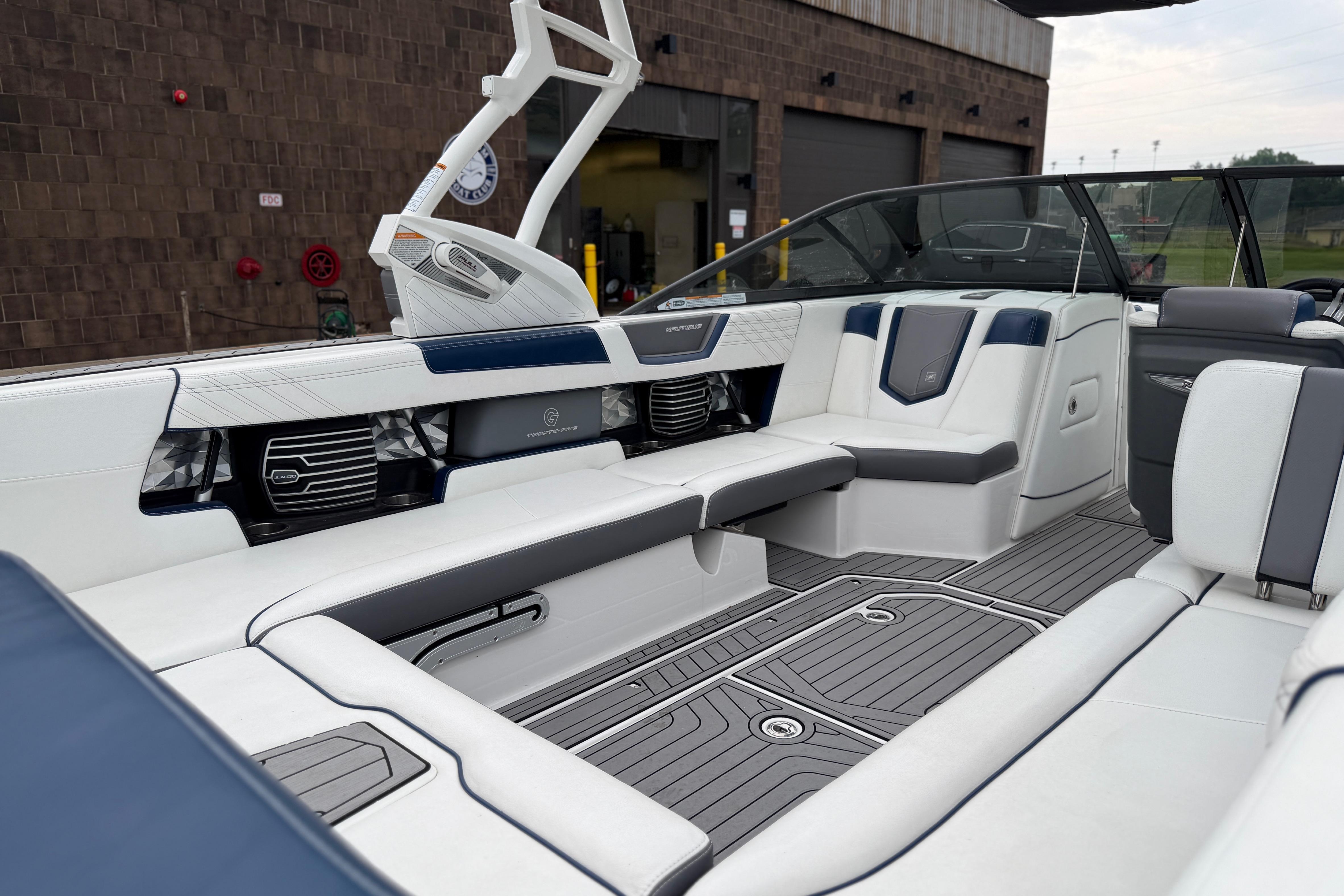 Interior of a 2016 Naitique G25 boat with sleek white and gray seating.