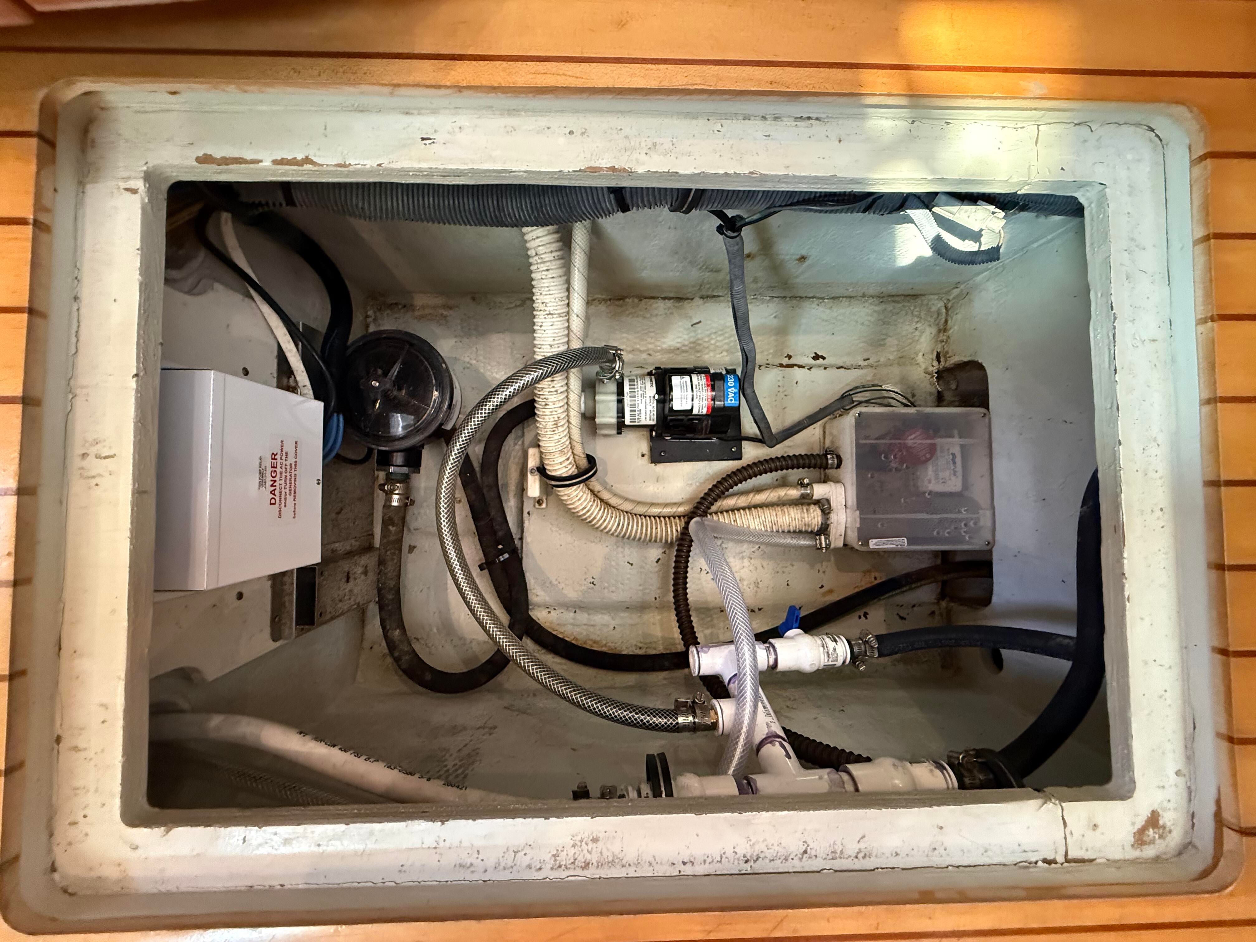 A view inside the engine compartment of a 2007 Chris-Craft Roamer 40 with various hoses and equipment.