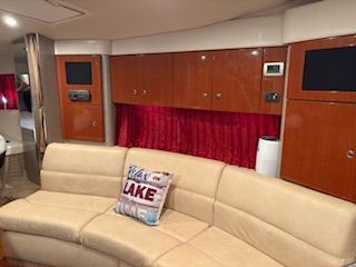 Interior of a 2007 Formula 34 Performance Cruiser with beige sofa and red curtains.