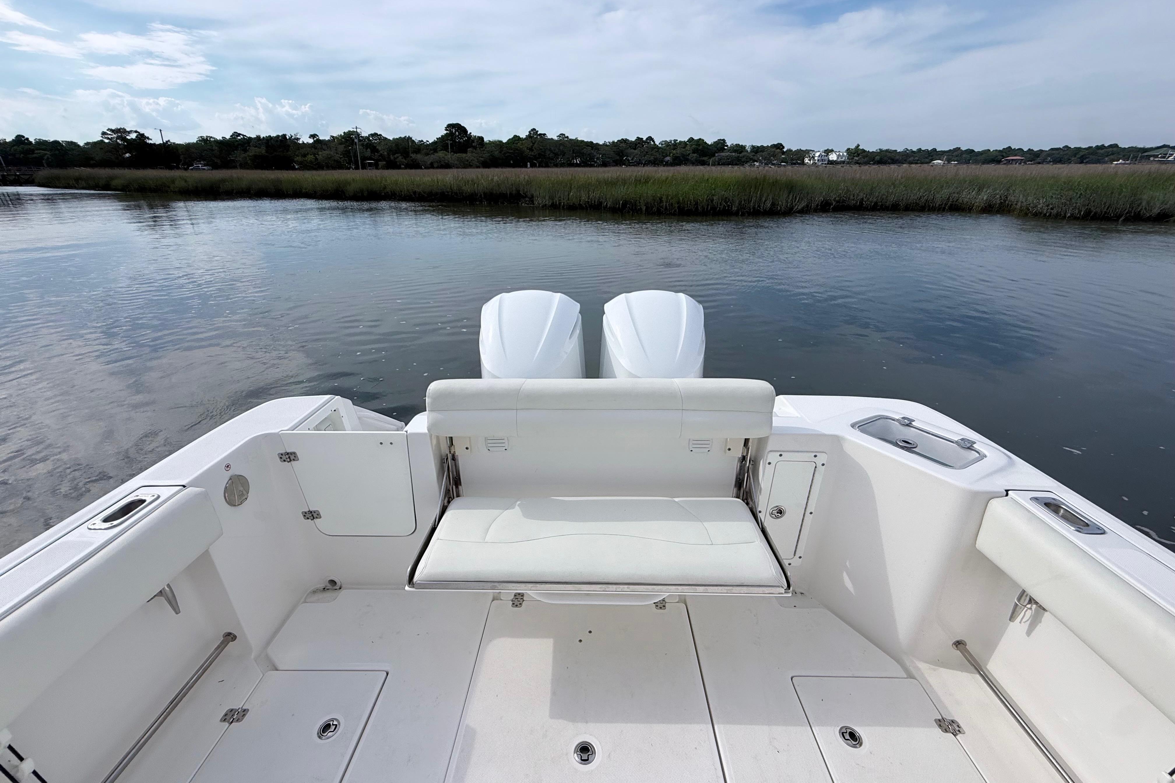 2022 Edgewater 280CC boat with dual engines, white seating, and scenic water view.