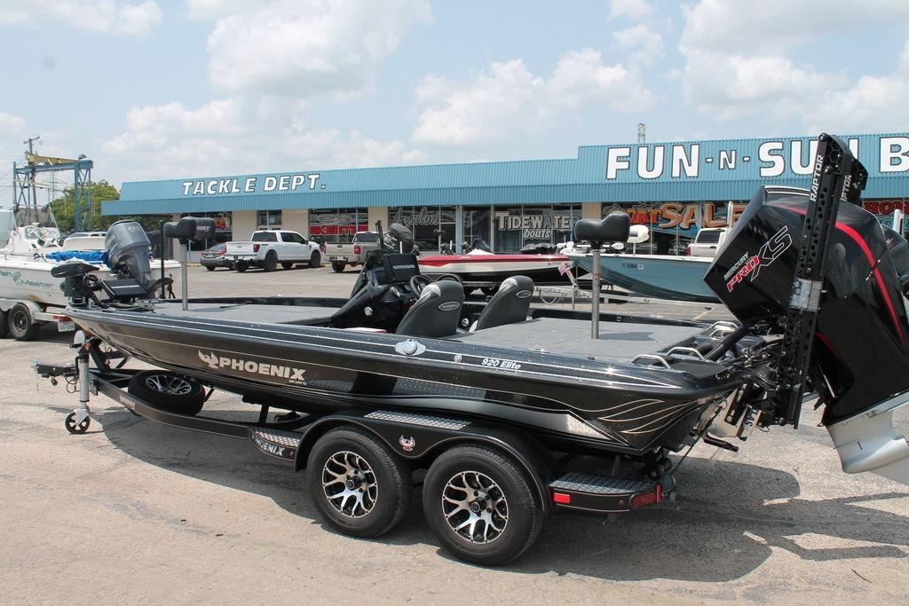 2025 Phoenix 920 Elite boat on trailer at dealership, sunny day.
