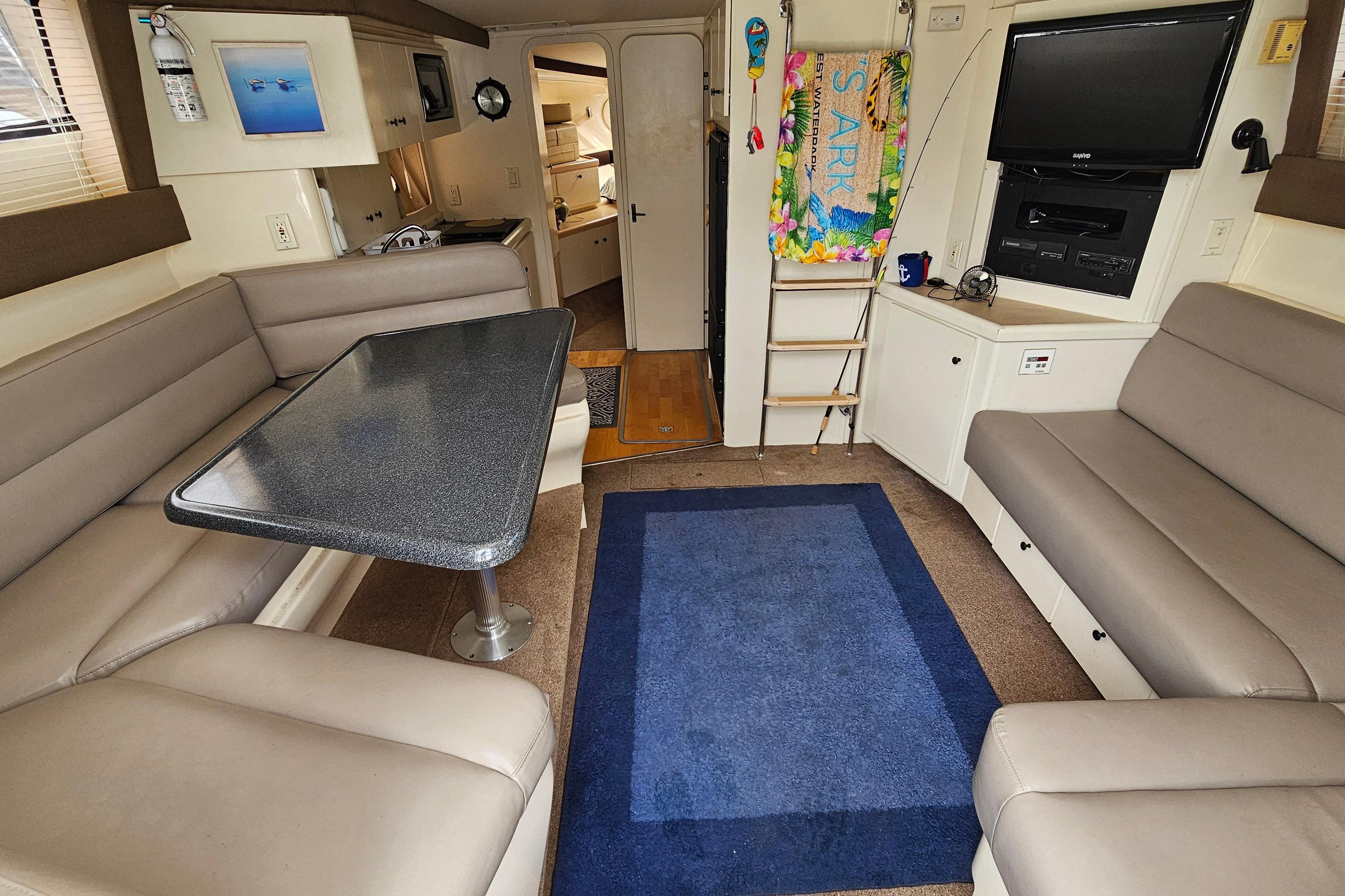 Interior of a 1999 Carver 350 Mariner yacht with seating, table, and entertainment area.