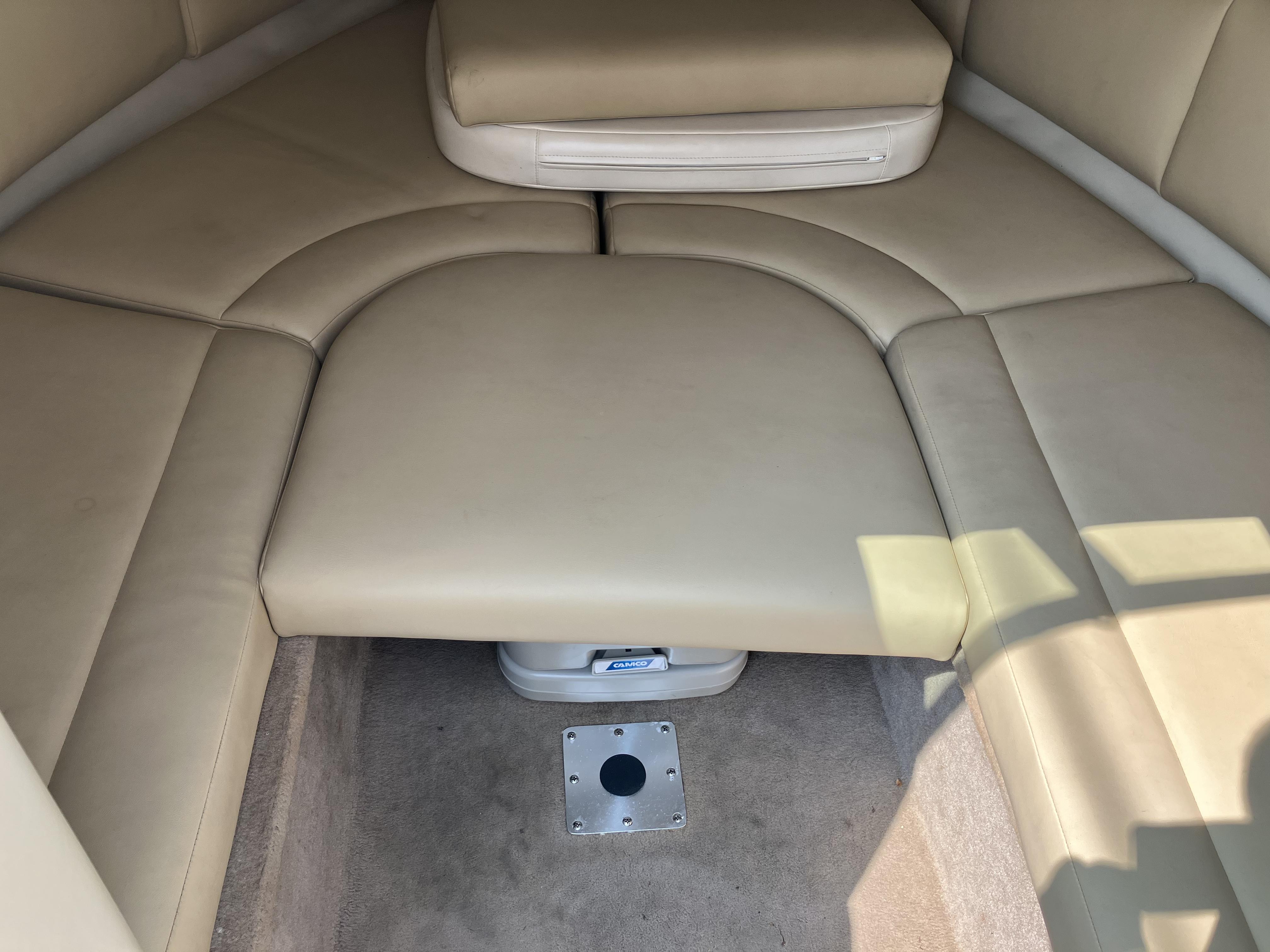 Interior of a Chaparral 235 SSi boat with beige upholstery and carpeted floor.
