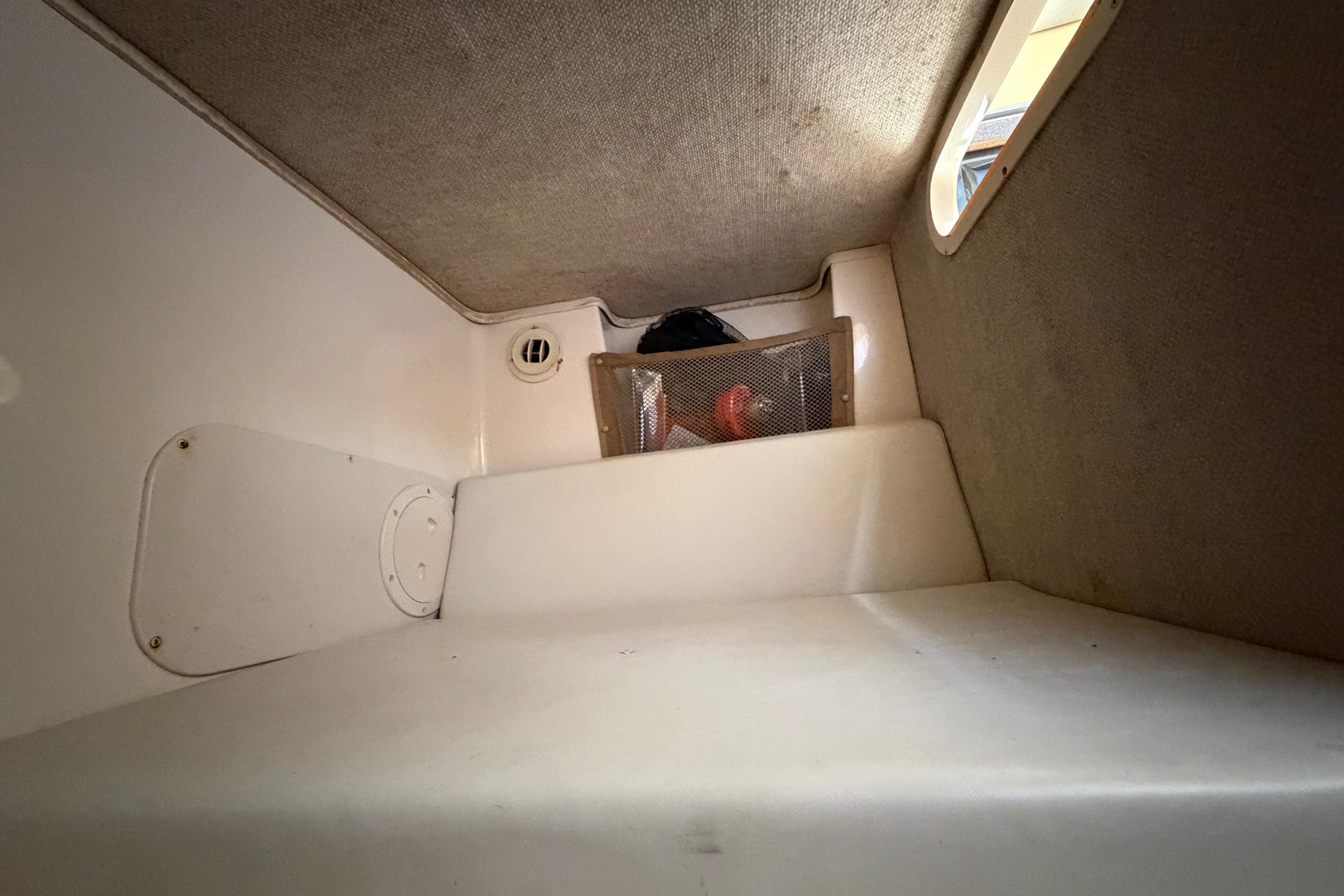 2006 Grady-White Sailfish 282 cabin interior with storage compartment and window.