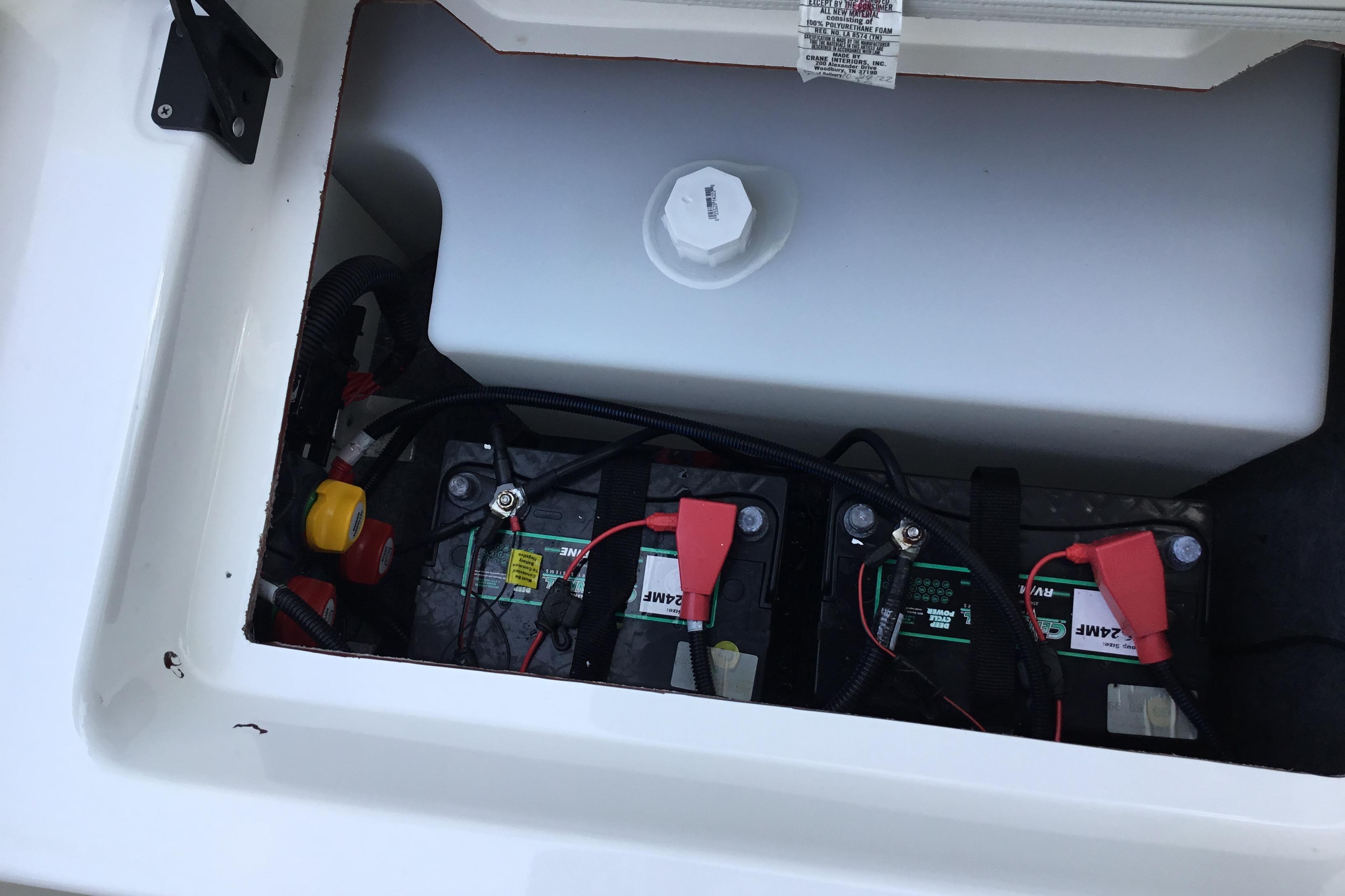 2023 Yamaha Boats 252XE battery compartment with dual batteries and wiring.
