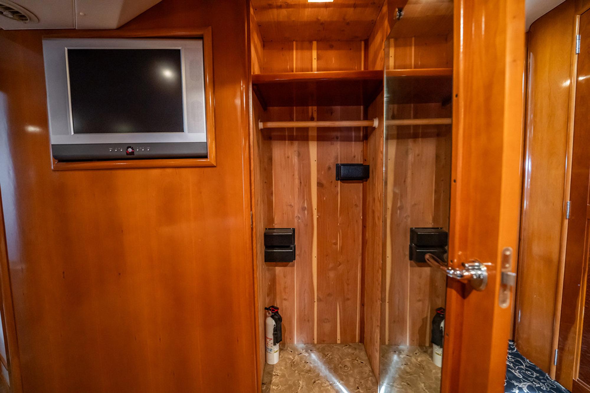 2005 Carver 56 Voyager interior with wooden closet and wall-mounted TV.