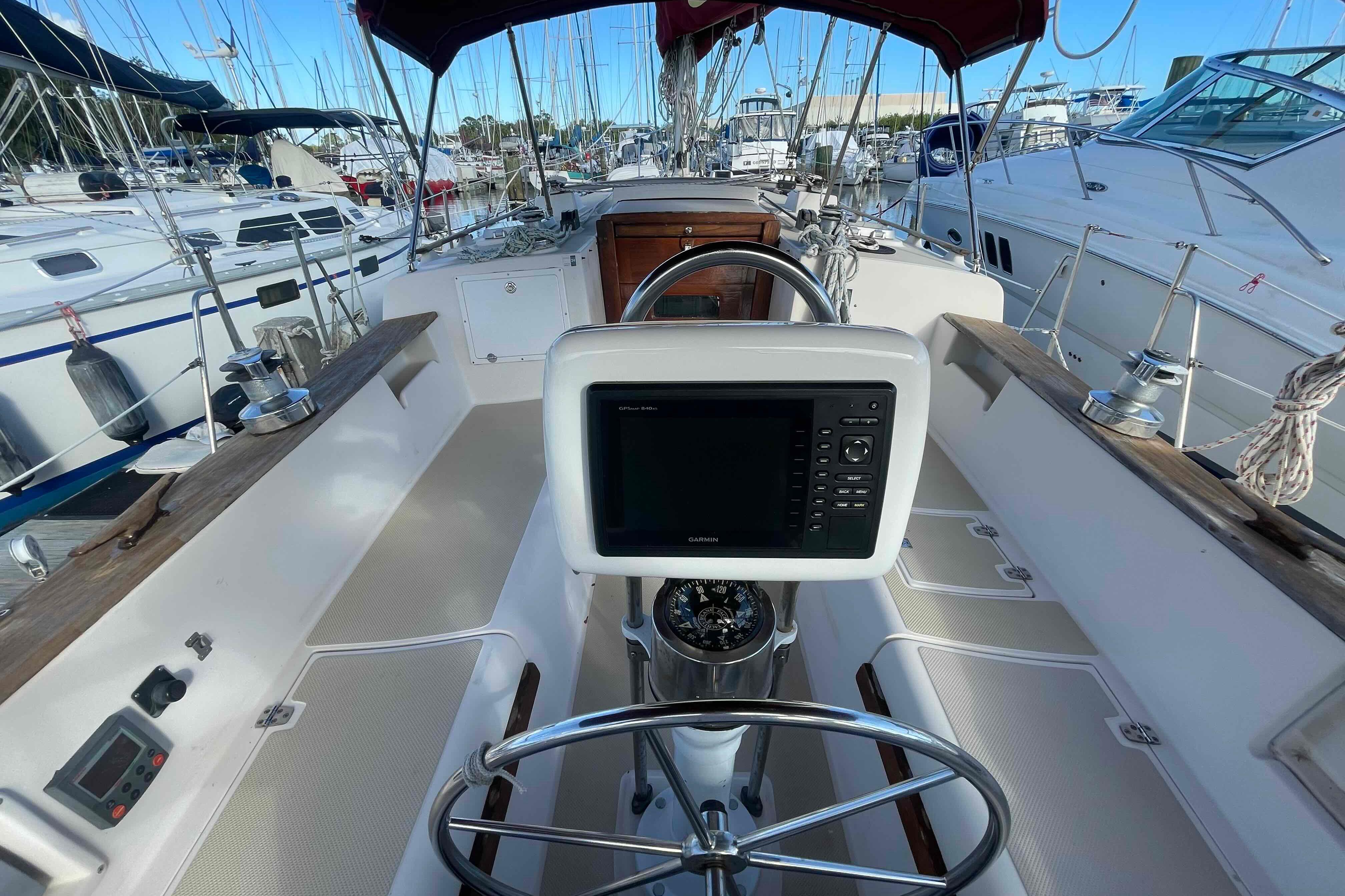 Cockpit of 1989 Island Packet 35 sailboat with navigation equipment and steering wheel.