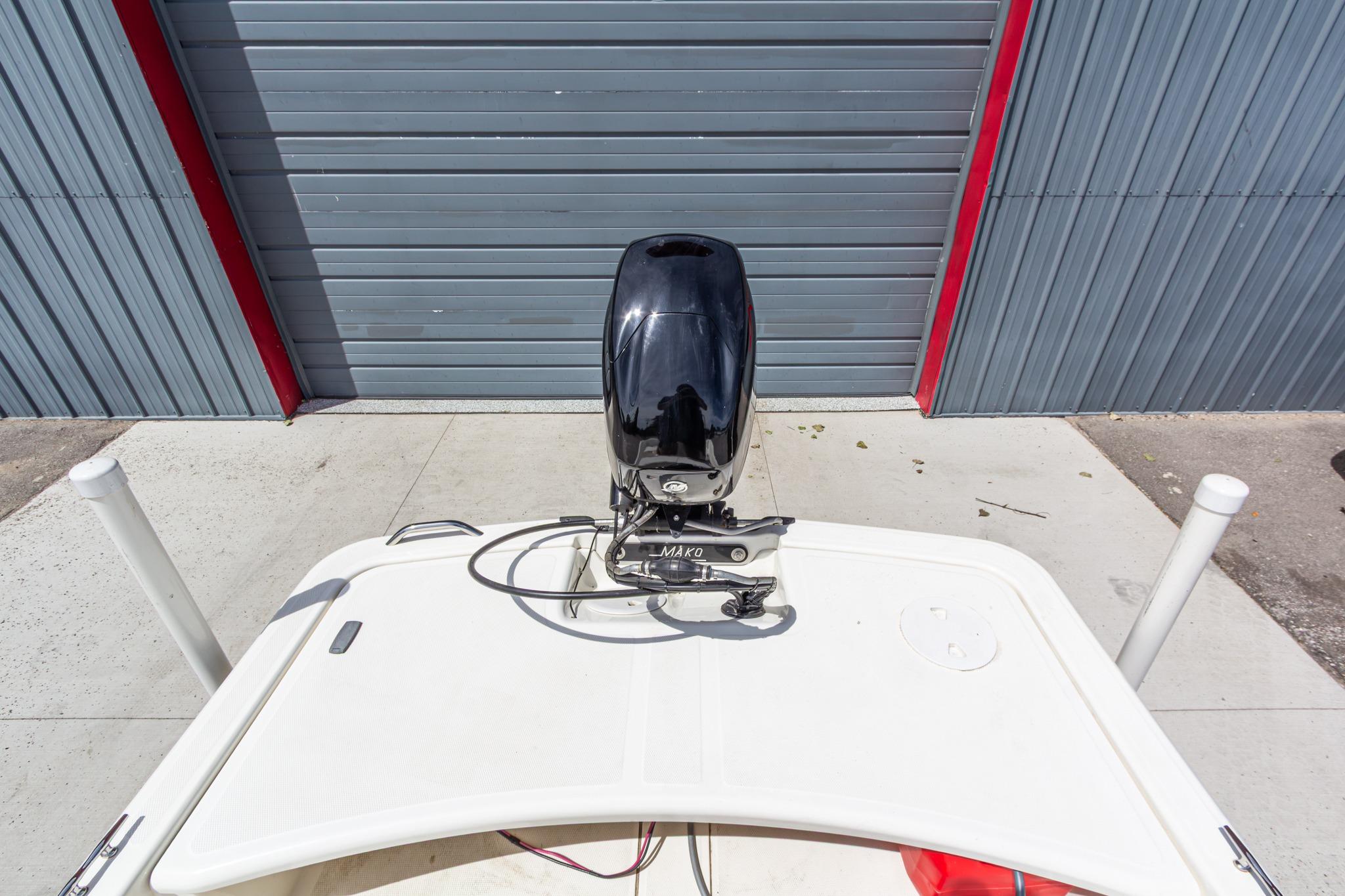 2020 Mako Pro Skiff 15 CC boat with outboard motor, parked near a garage.