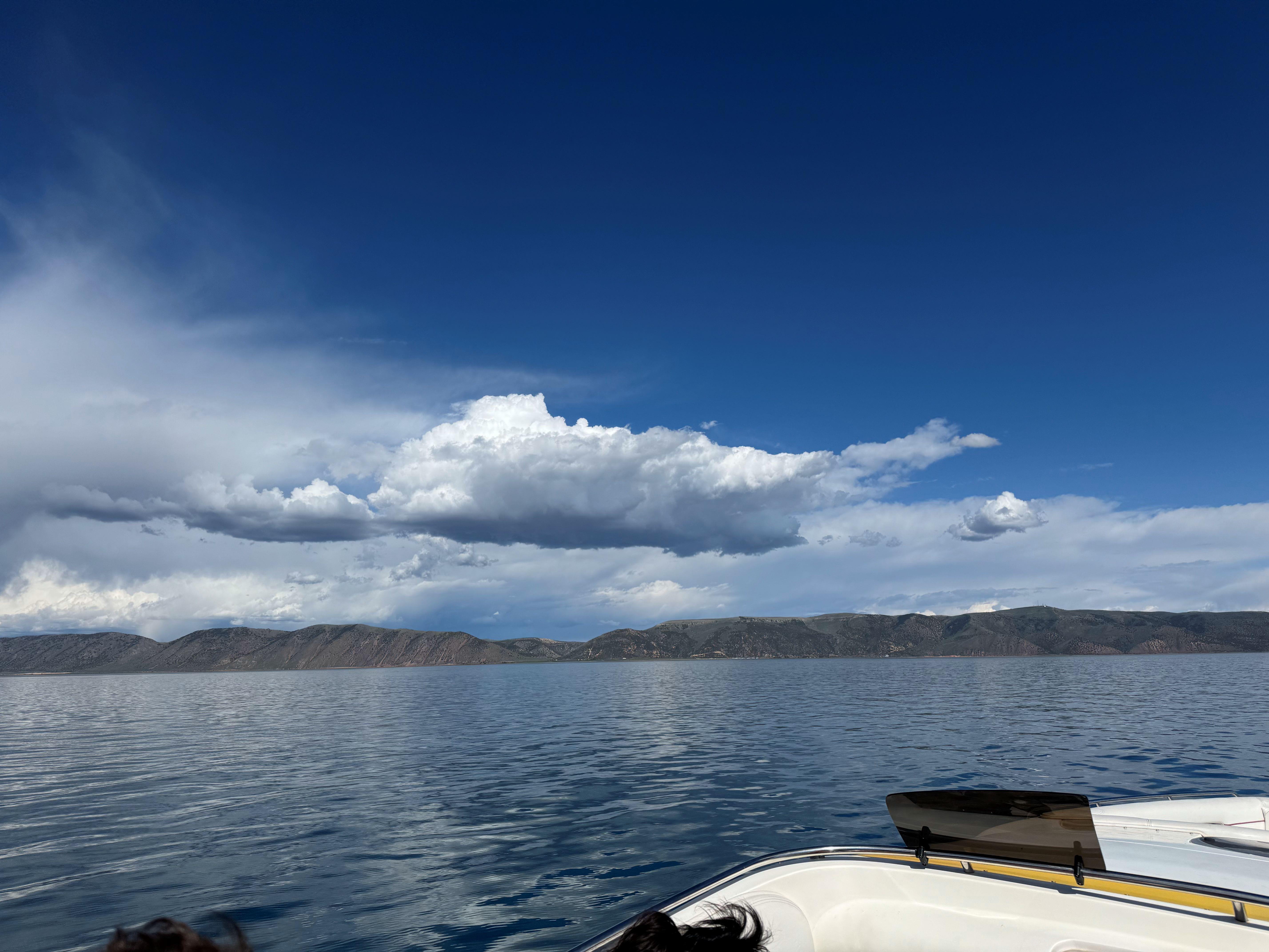 Boat on serene lake under blue sky with clouds, Advantage Victory 2002.