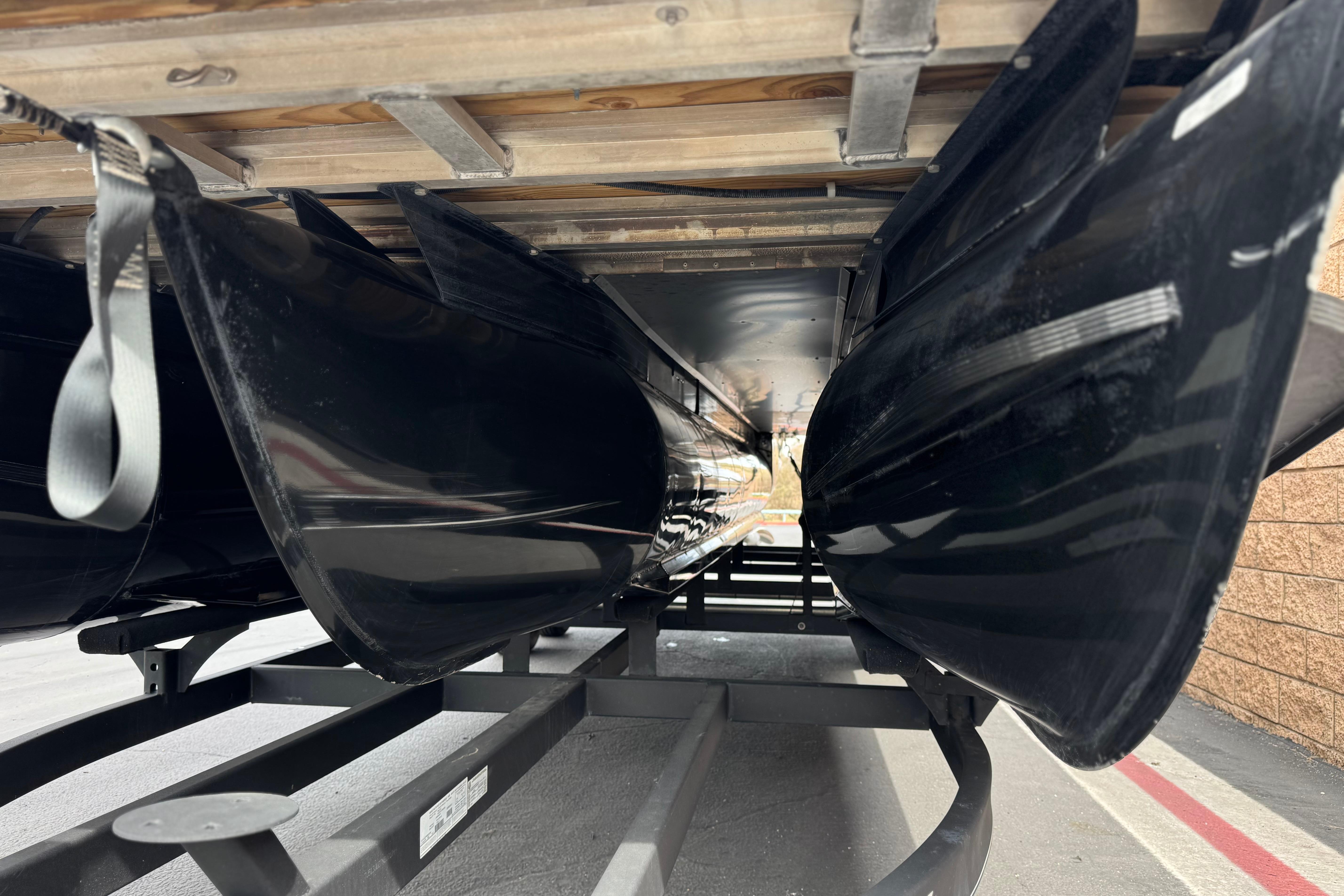 Underneath view of a 2022 Regency 250 DL3 pontoon boat on a trailer.