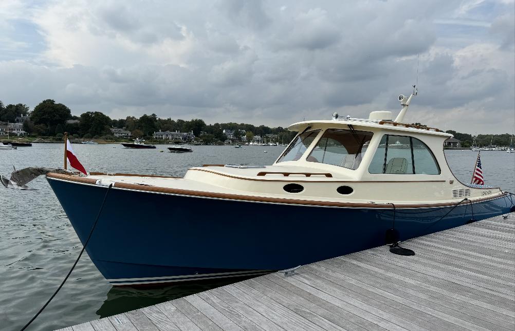 2018 Hinckley Picnic Boat 37 MKIII docked on a calm lake under cloudy skies.