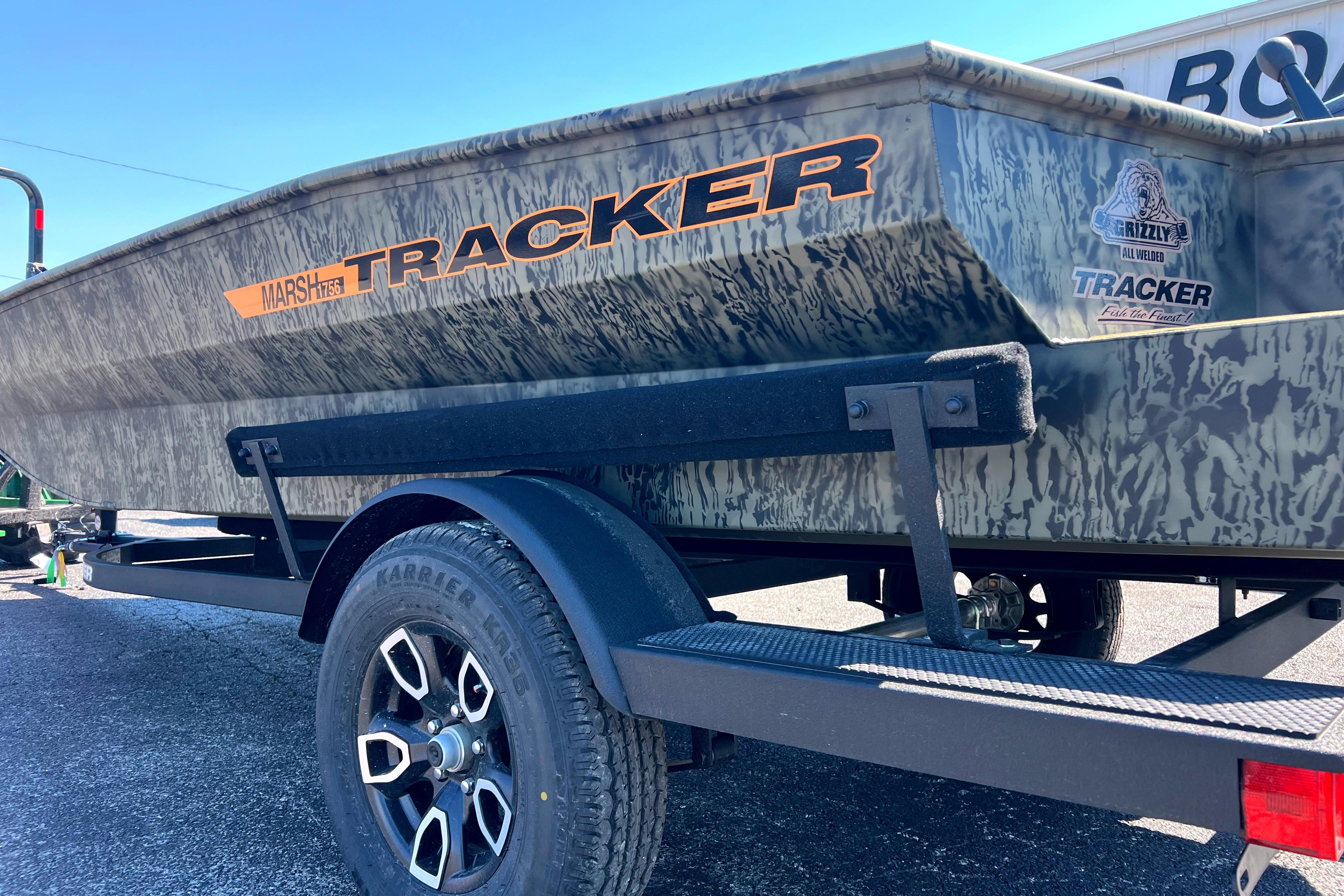 2026 Tracker Grizzly 1756 T Marsh boat on trailer, camo design, outdoor setting.