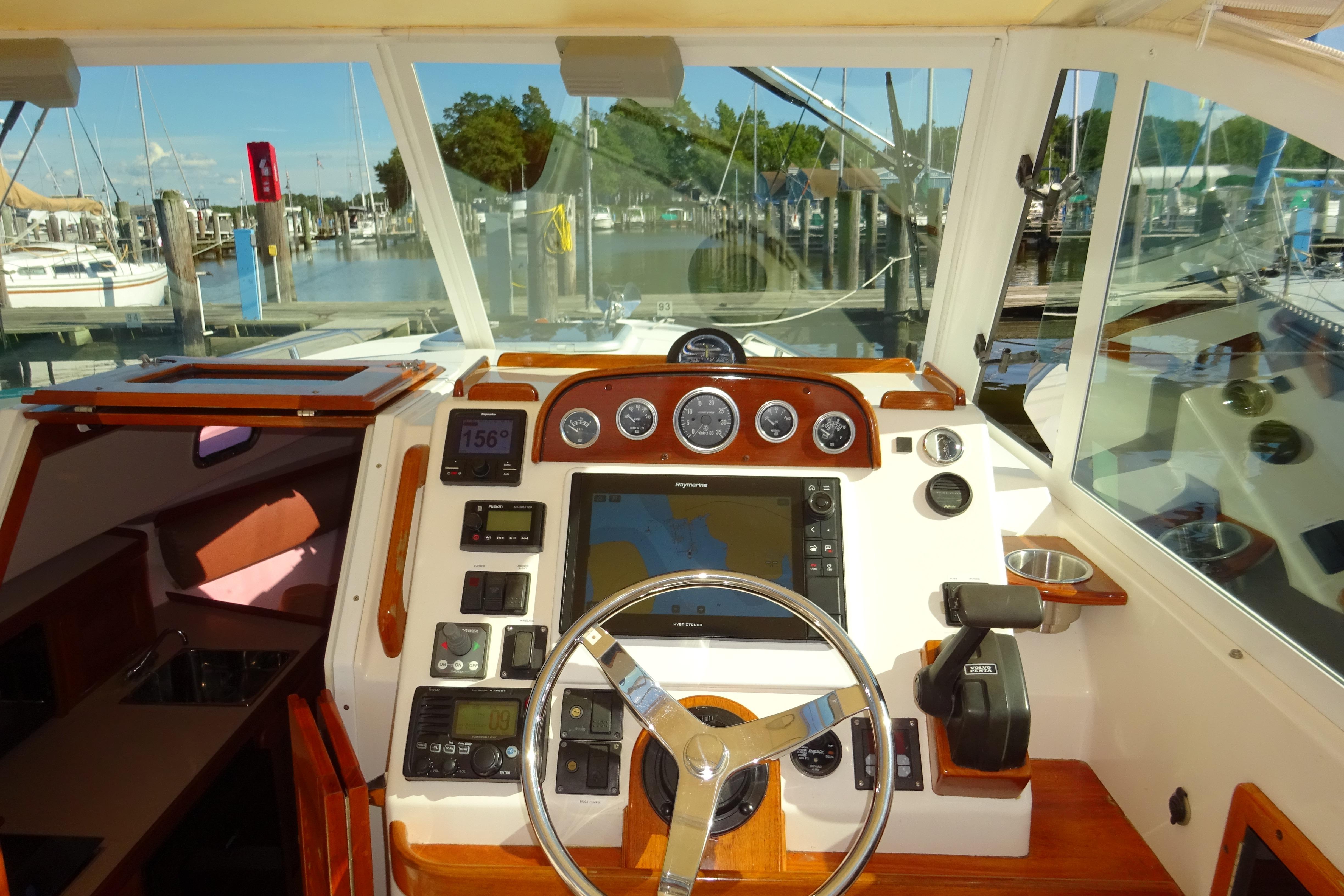 2007 Hunt Yachts Surfhunter 29 helm with navigation instruments and marina view.
