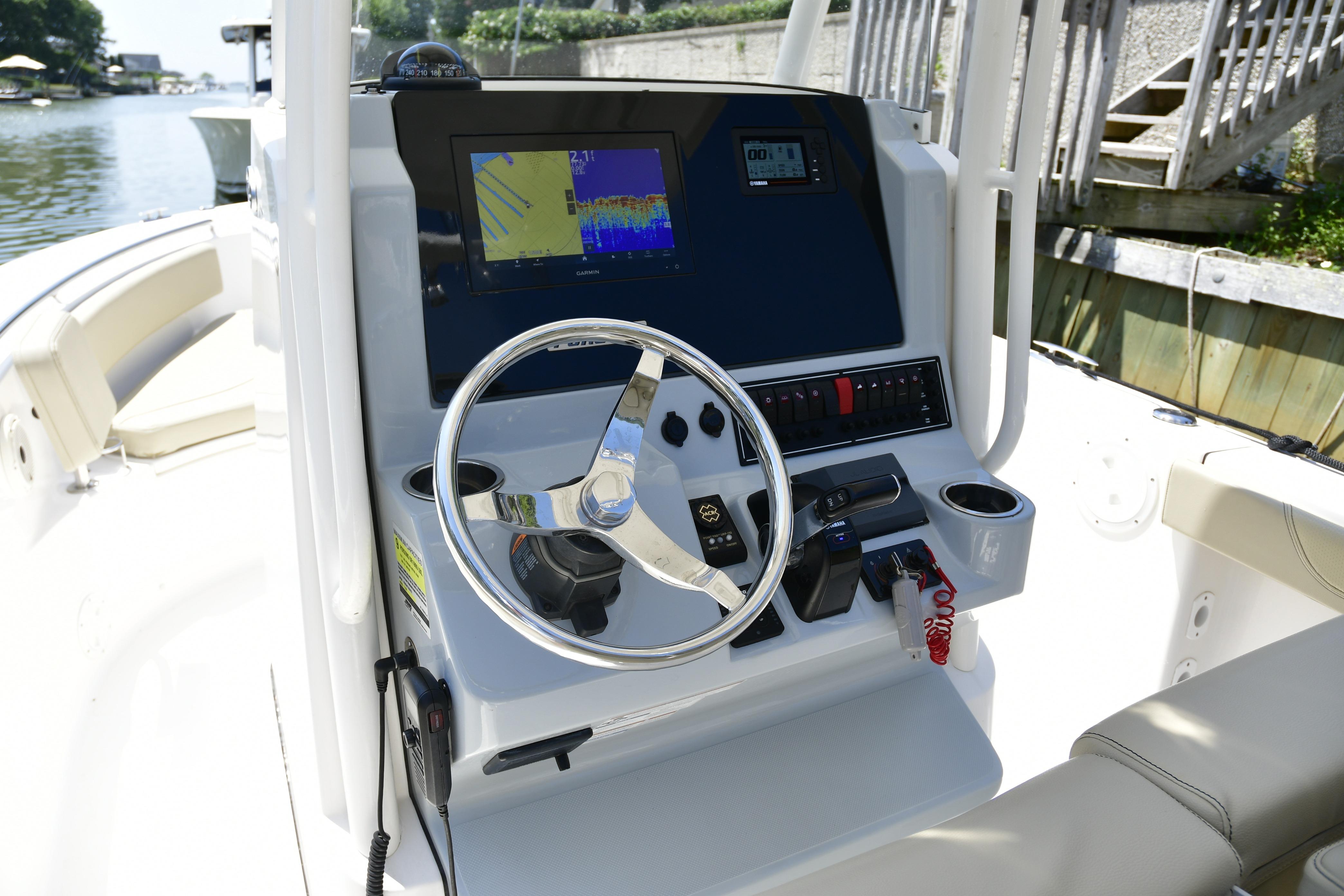 2020 Pursuit C 238 Center Console boat dashboard with steering wheel and navigation display.