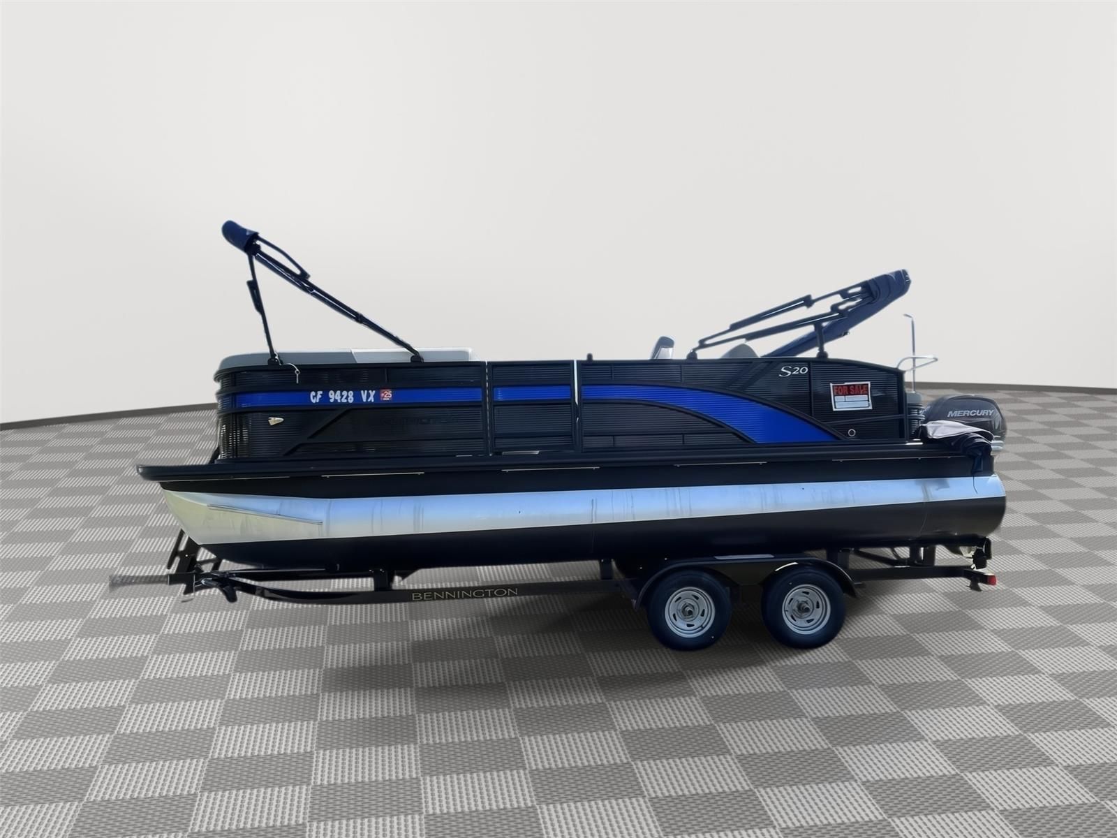 A 2025 Bennington S20 pontoon boat on a trailer in a showroom.
