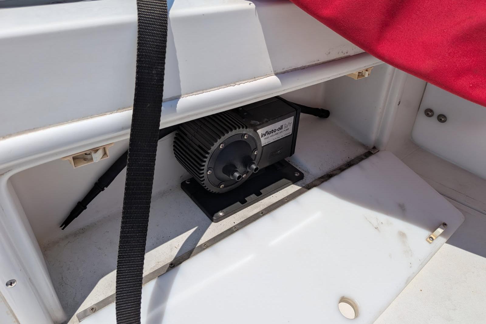 Storage compartment in a 2020 Cobalt 206 boat with an inflator device.