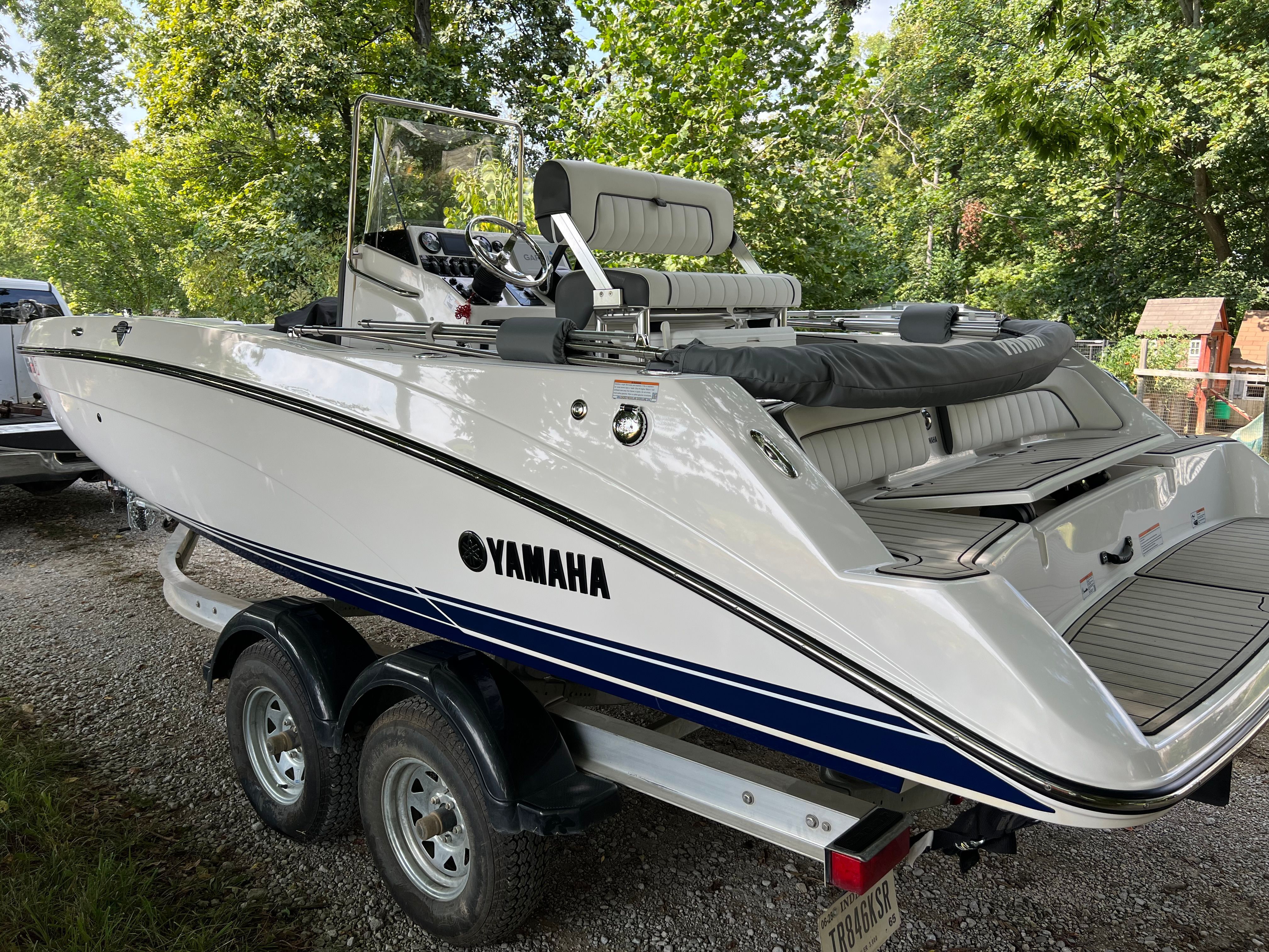 2022 Yamaha Boats 210 FSH Deluxe on trailer outdoors.