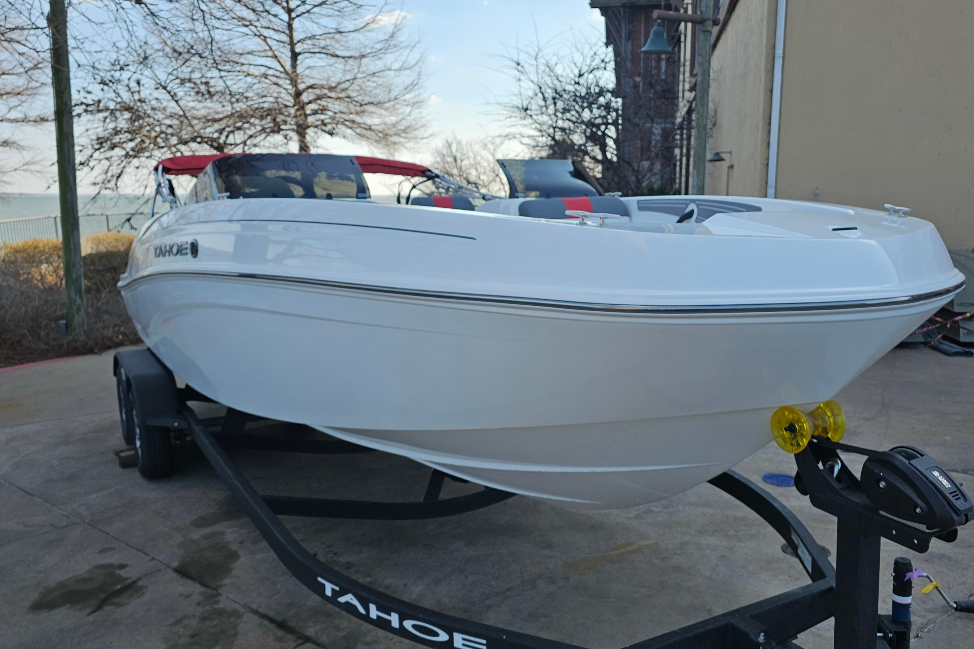 2026 Tahoe T21 boat on trailer, parked outdoors near a lake.