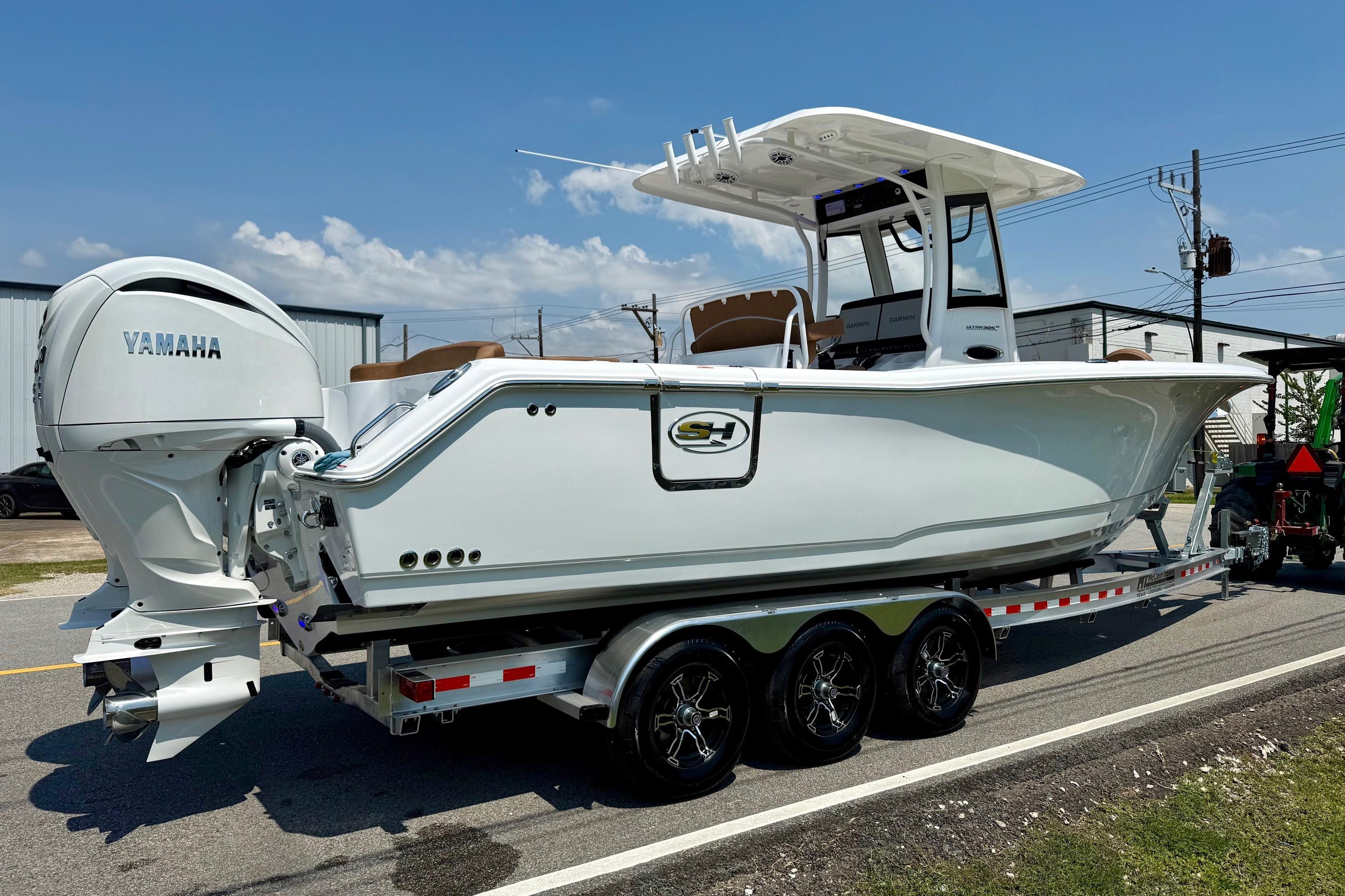 2026 Sea Hunt Ultra 305 SE boat on trailer with Yamaha engines, parked outdoors.