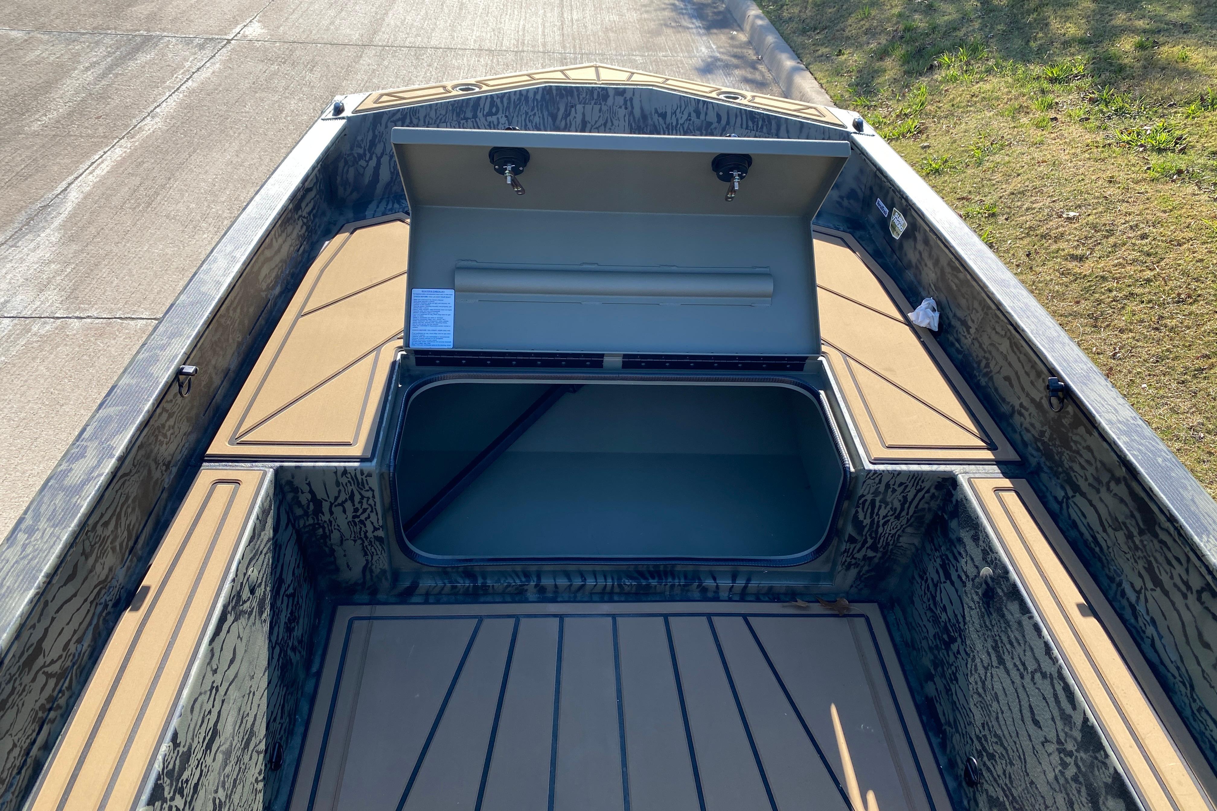 2026 Tracker Grizzly 1650 T Prairie Wings Edition boat interior with open storage compartment.
