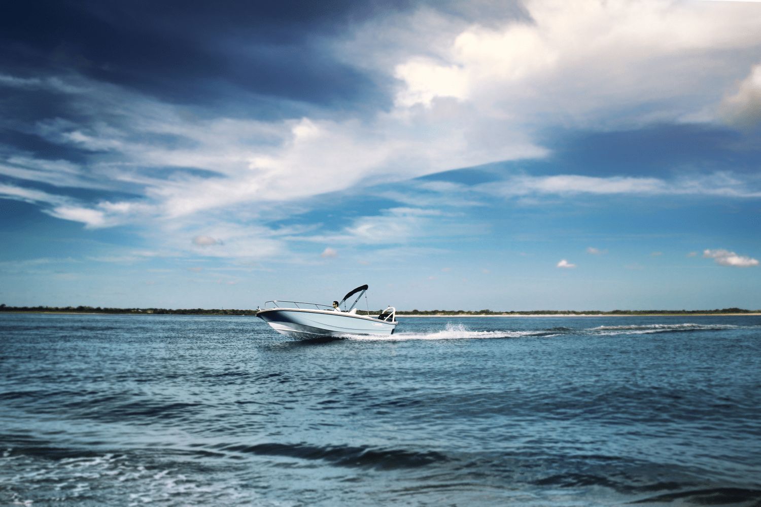 A 2026 Boston Whaler 160 Super Sport cruising on calm water under a cloudy sky.