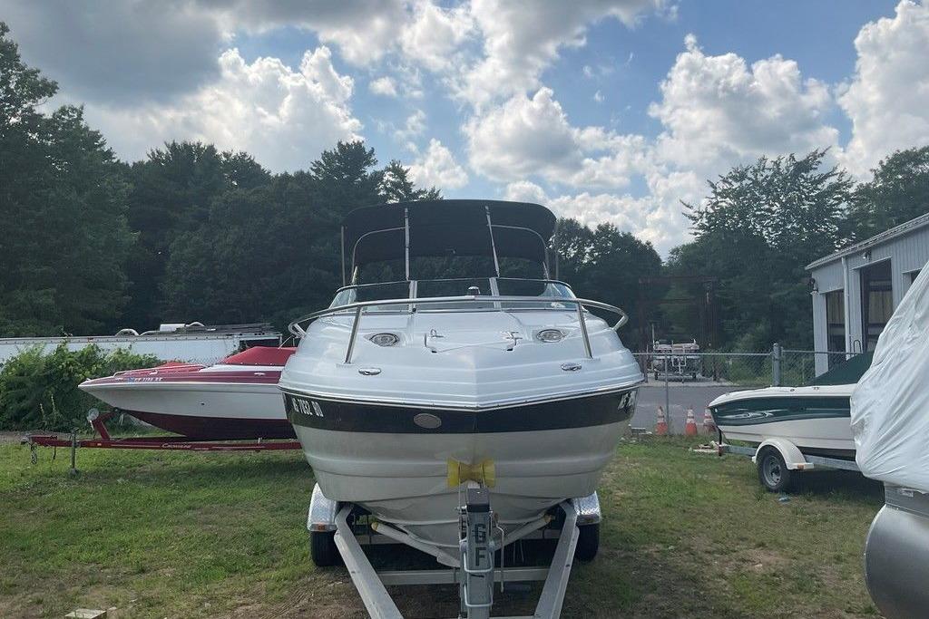2015 Crownline 236 SC boat on trailer, parked outdoors under cloudy sky.
