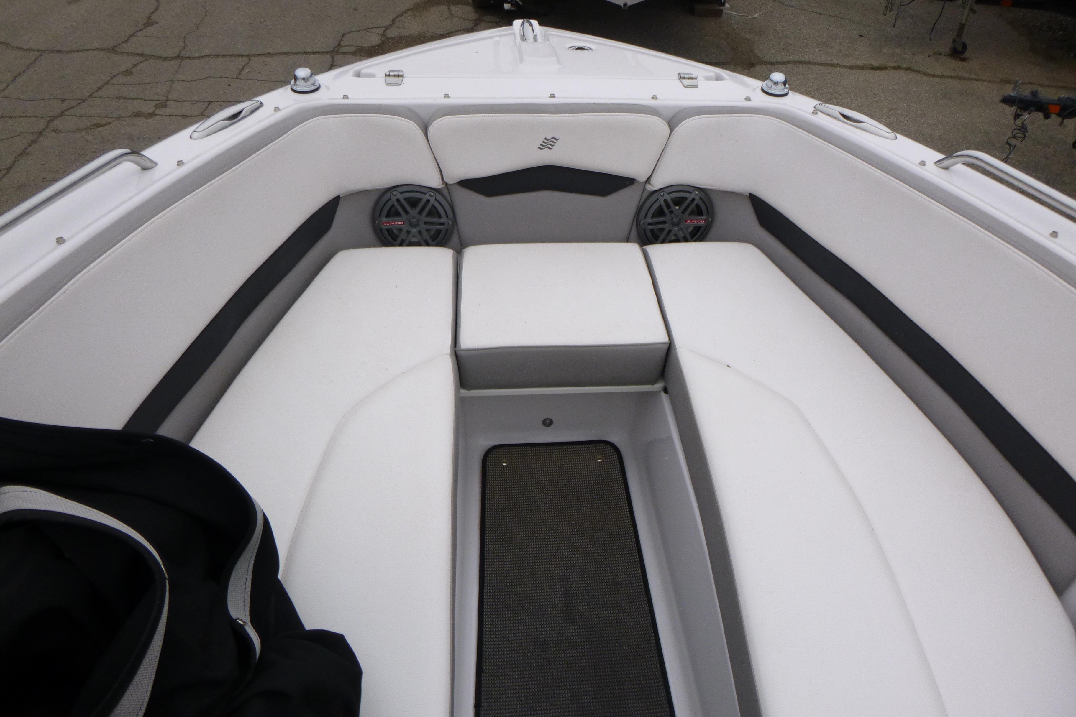 Interior of 2017 Four Winns H260 boat with white cushioned seating and speakers.