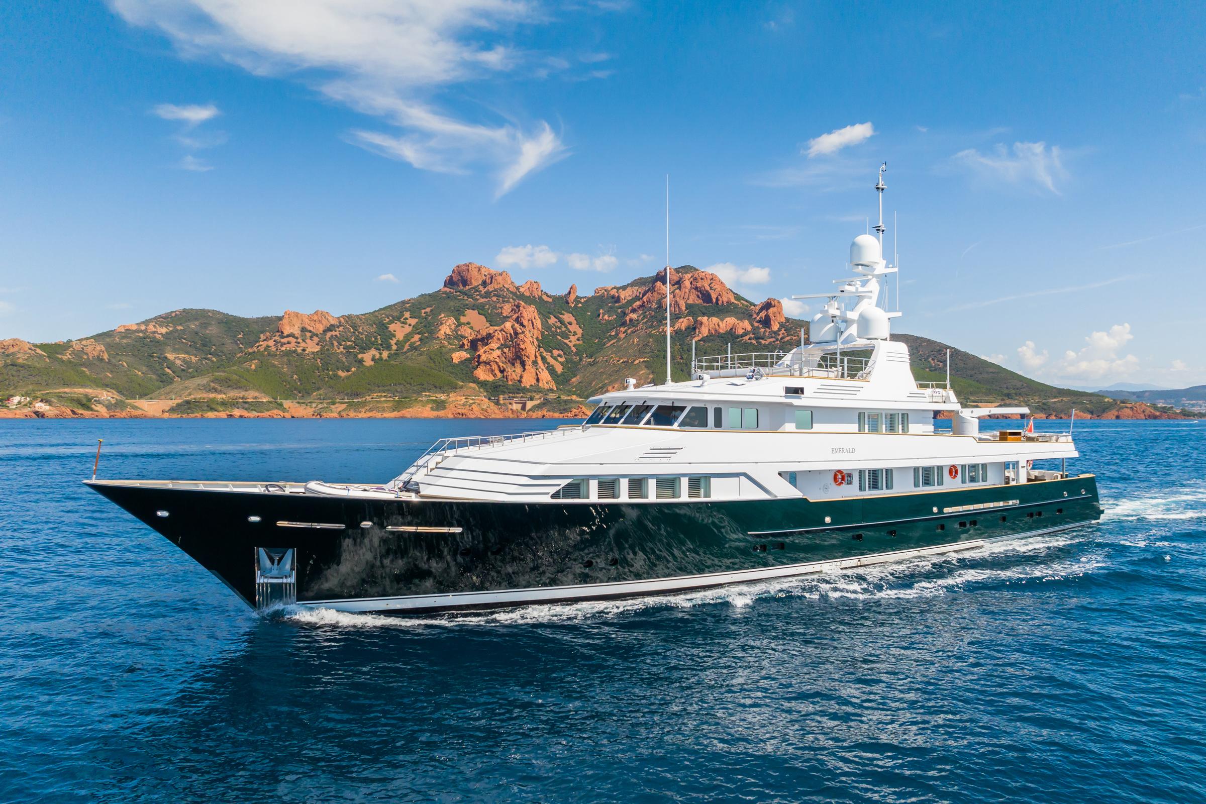 Luxurious 1990 Feadship yacht cruising in scenic coastal waters.