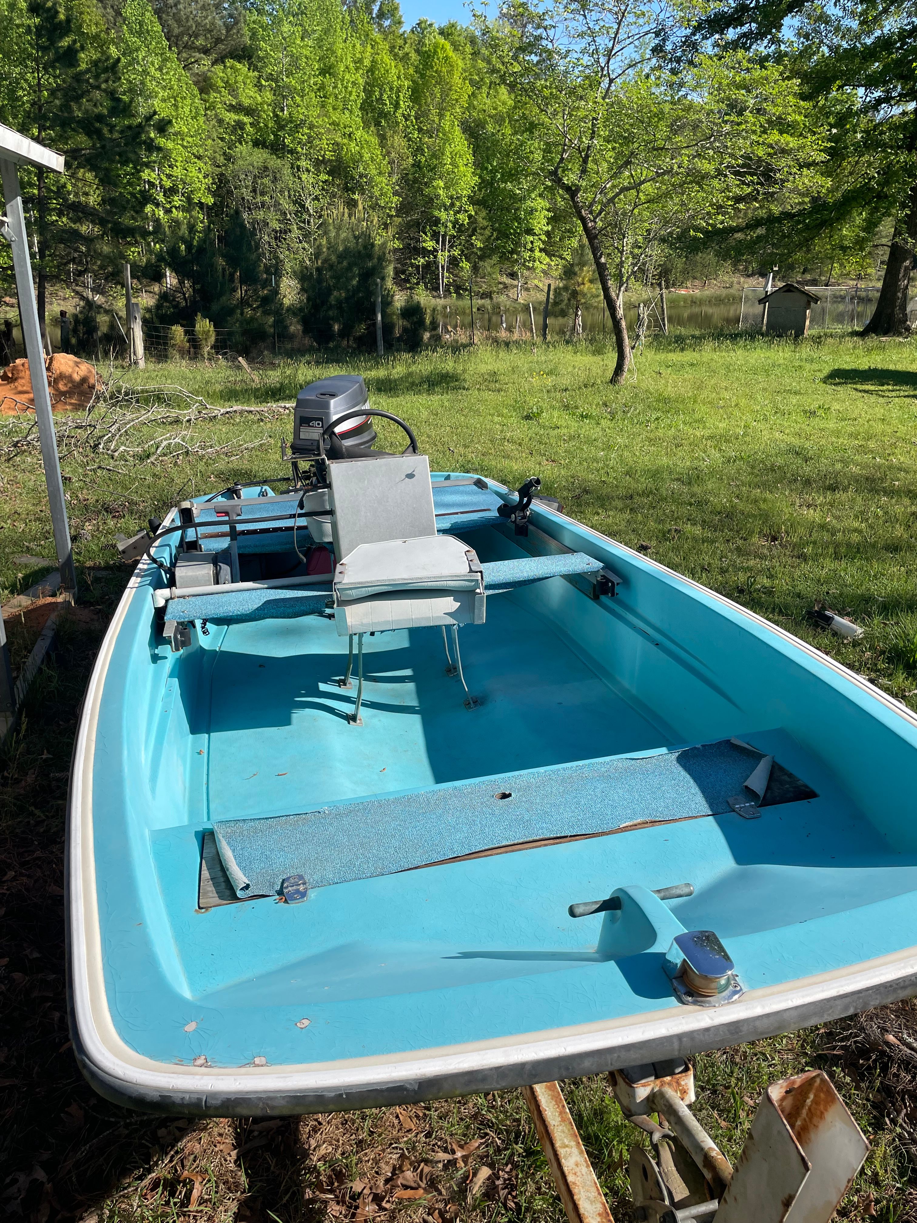1964 Boston Whaler 13’ 6” boat parked on grass.