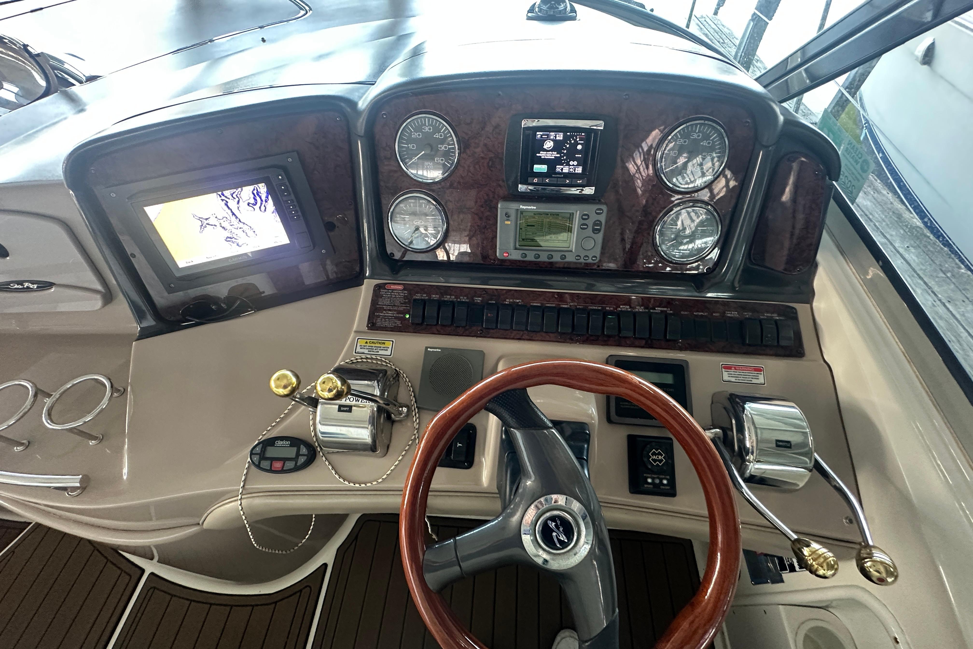 2004 Sea Ray 420 Sundancer helm with navigation controls and wooden steering wheel.