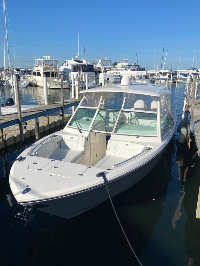 2023 Cobia 330 boat docked in marina, clear sky.