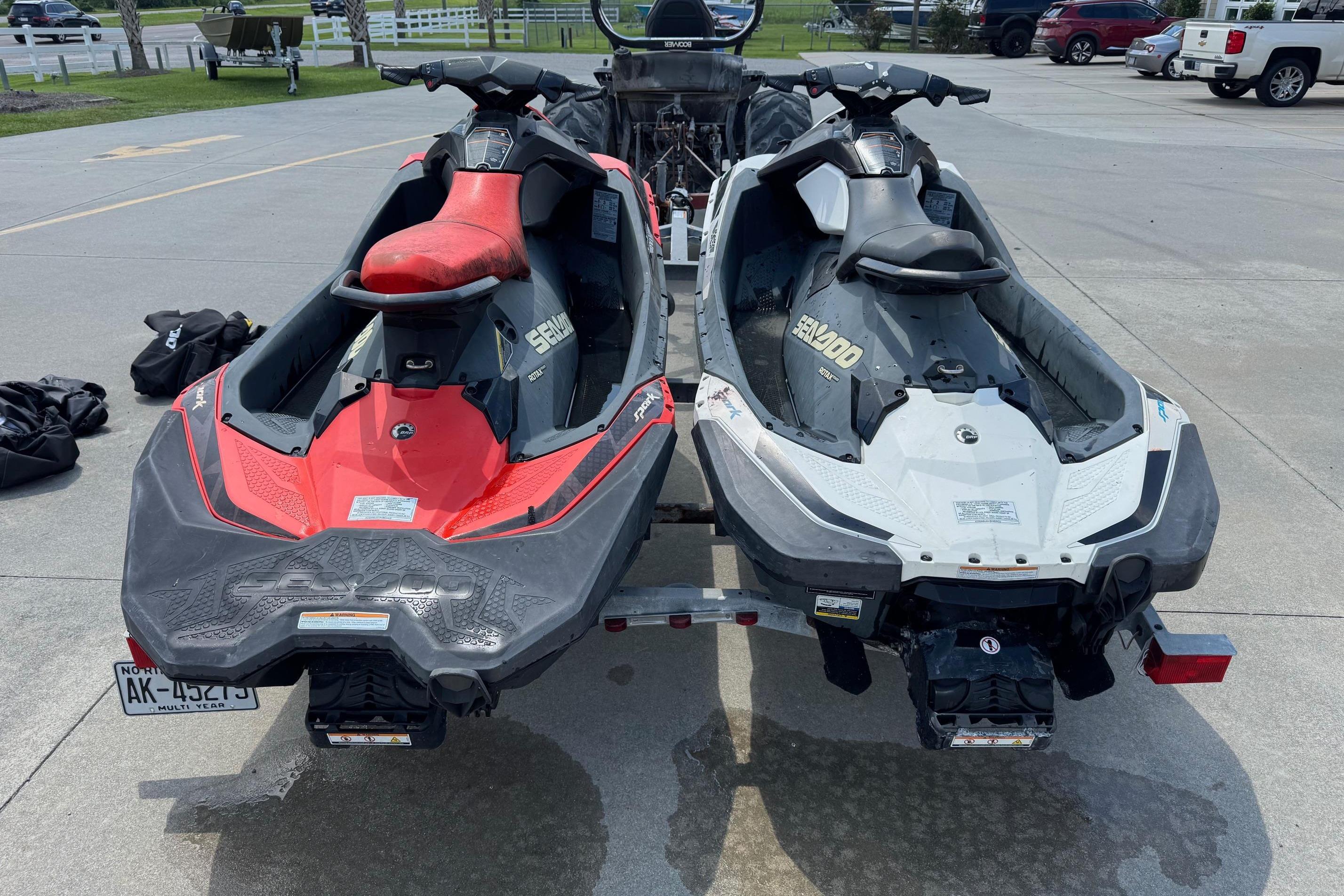 Two 2017 Sea-Doo Spark 2up jet skis on a trailer in a parking lot.