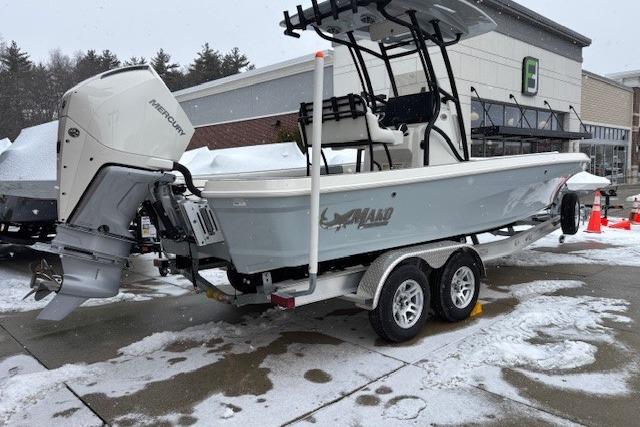 2026 Mako 24 APEX boat on trailer, snowy outdoor setting, Mercury engine visible.